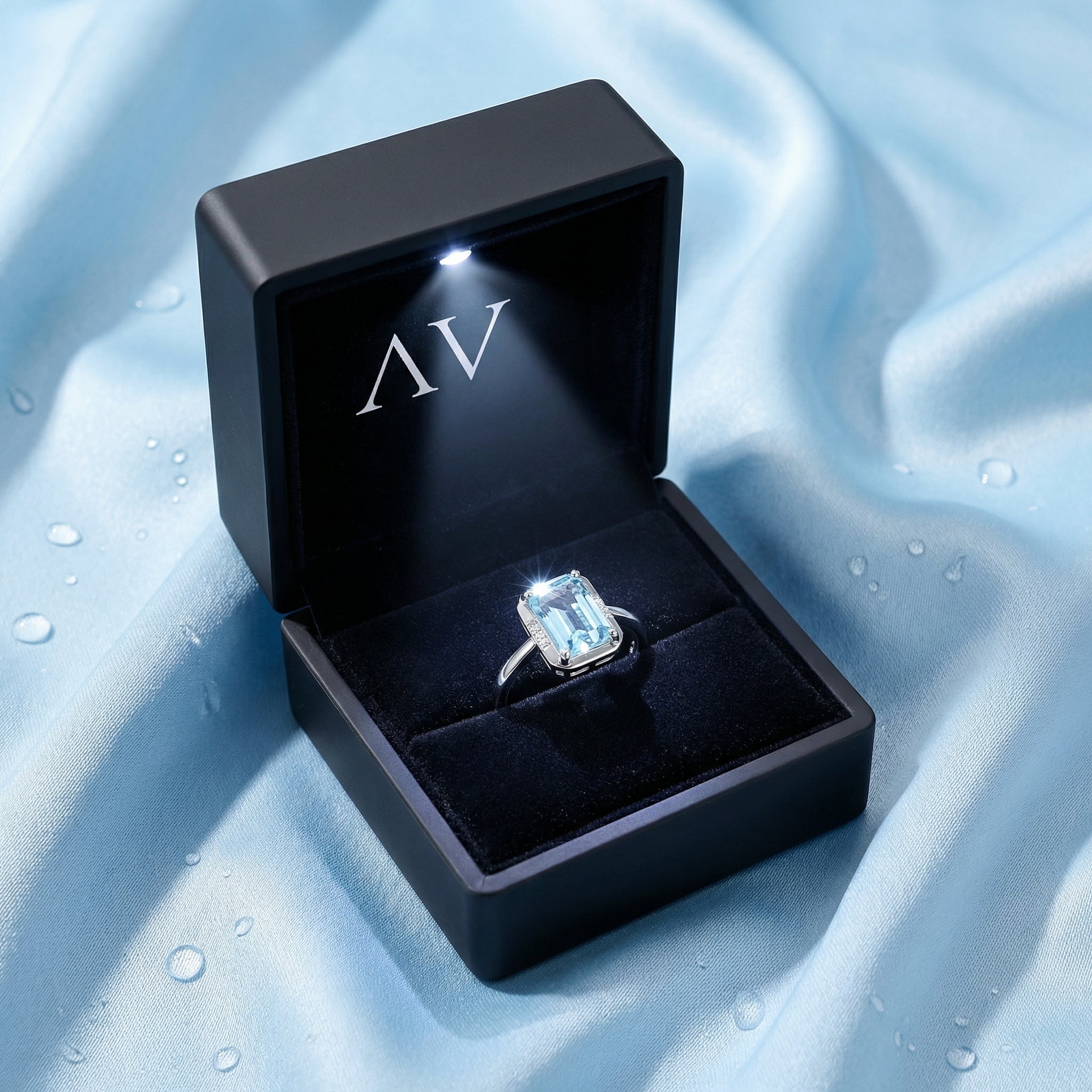 Emerald cut simulated aquamarine sterling silver ring inside a black LED-lit jewelry presentation box.