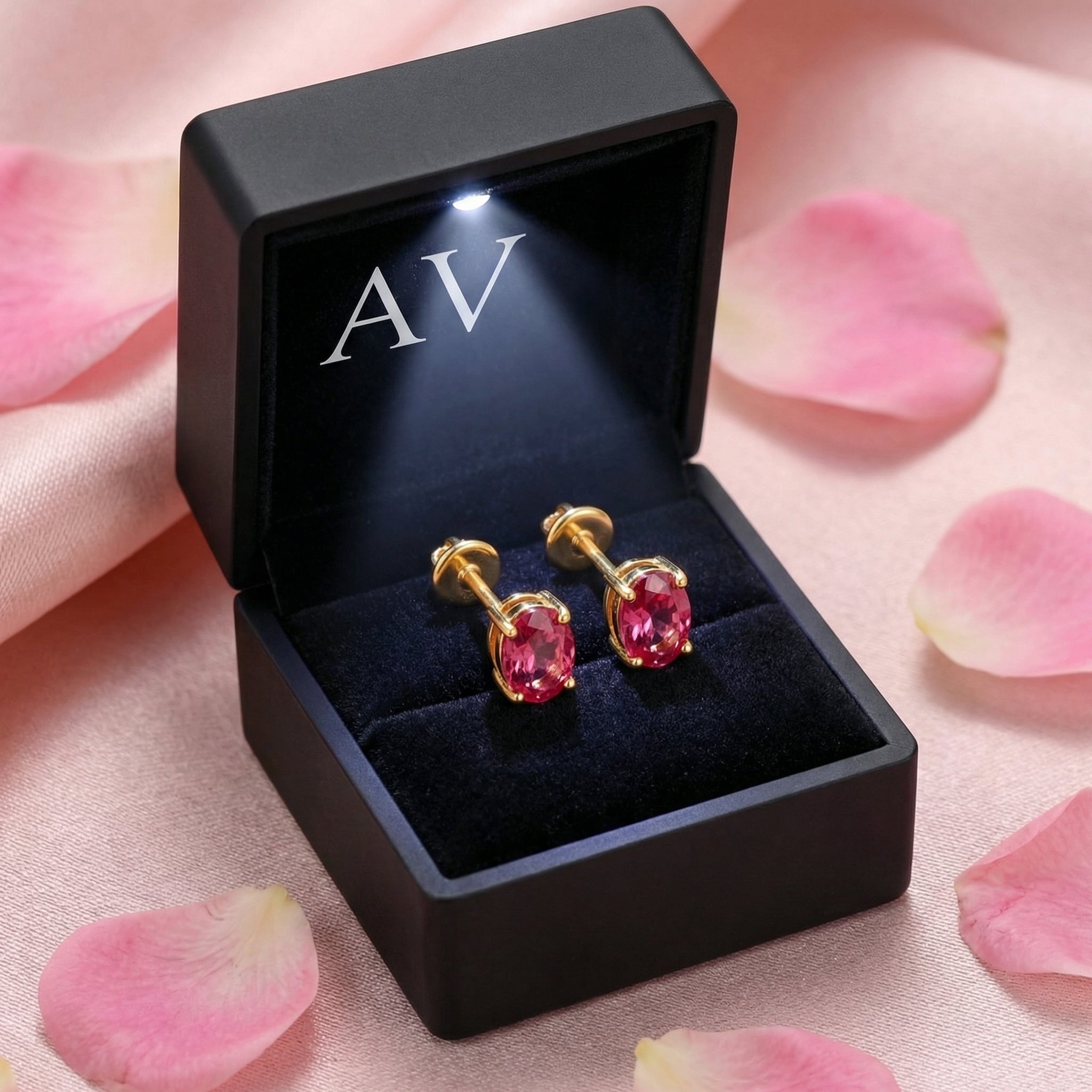 Oval simulated pink tourmaline stud earrings in 18K gold vermeil inside a black LED-lighted jewelry box.