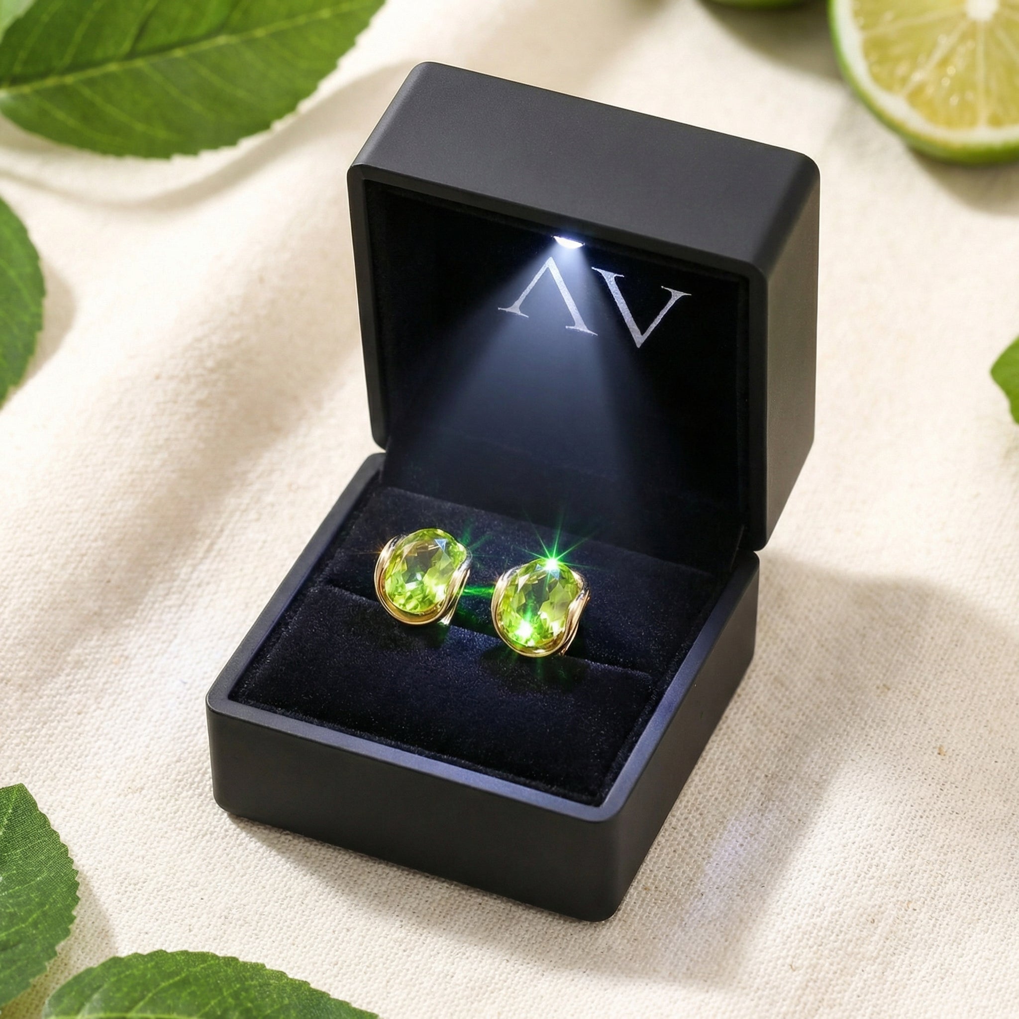 Pair of oval simulated peridot earrings in 18K gold vermeil inside a black LED-lit presentation gift box.