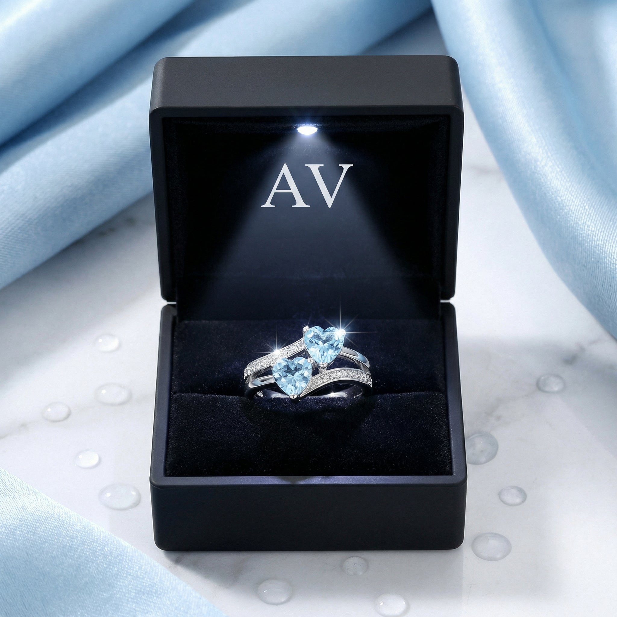 The Lyrelle heart-cut simulated aquamarine sterling silver ring inside a black lighted jewelry presentation box.