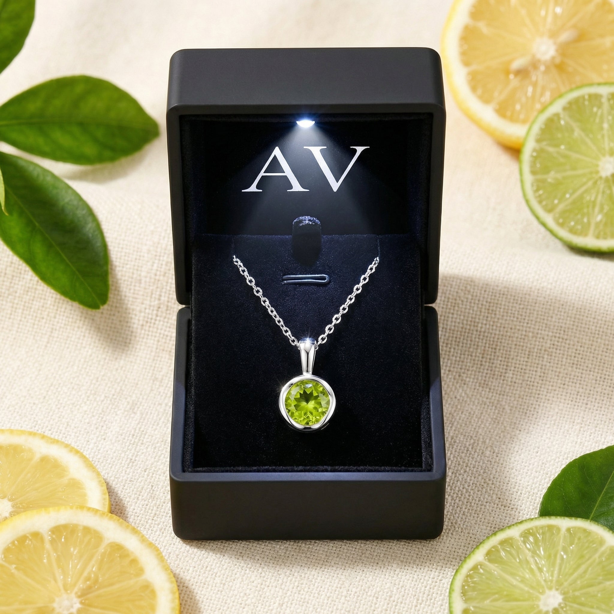 Round-cut simulated peridot S925 sterling silver necklace in a black LED-lit box with citrus props.