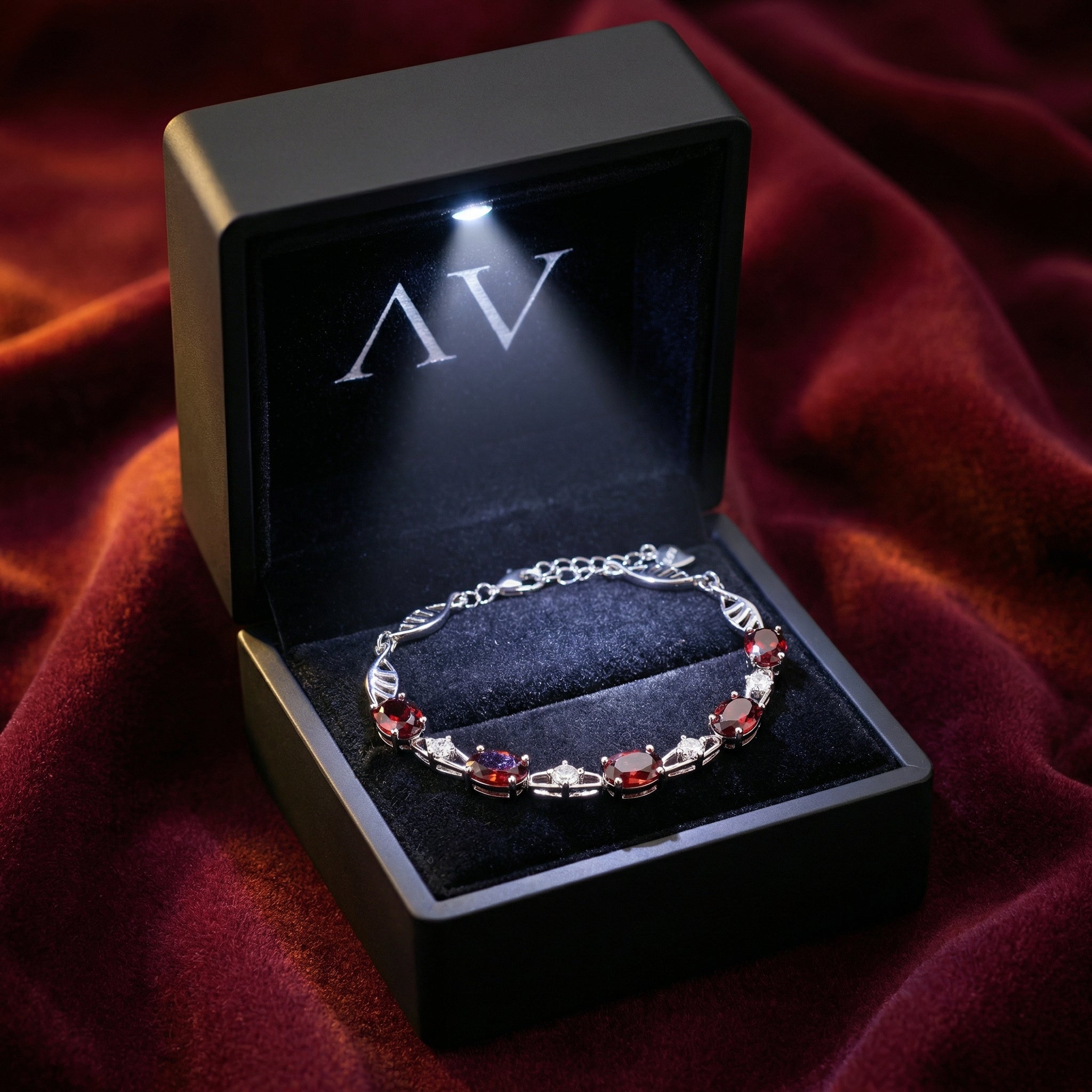 Thalassa helix bracelet with oval red garnets in a premium lighted black jewelry gift box.