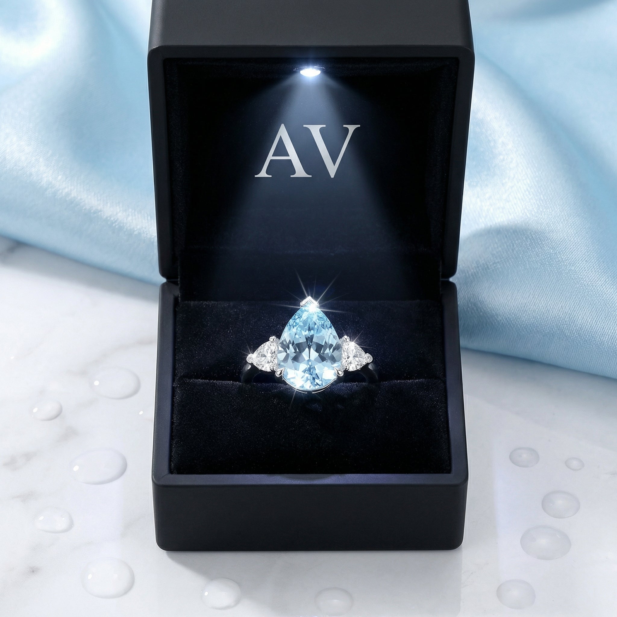 Pear cut simulated aquamarine sterling silver ring inside a black LED-lit jewelry presentation box.