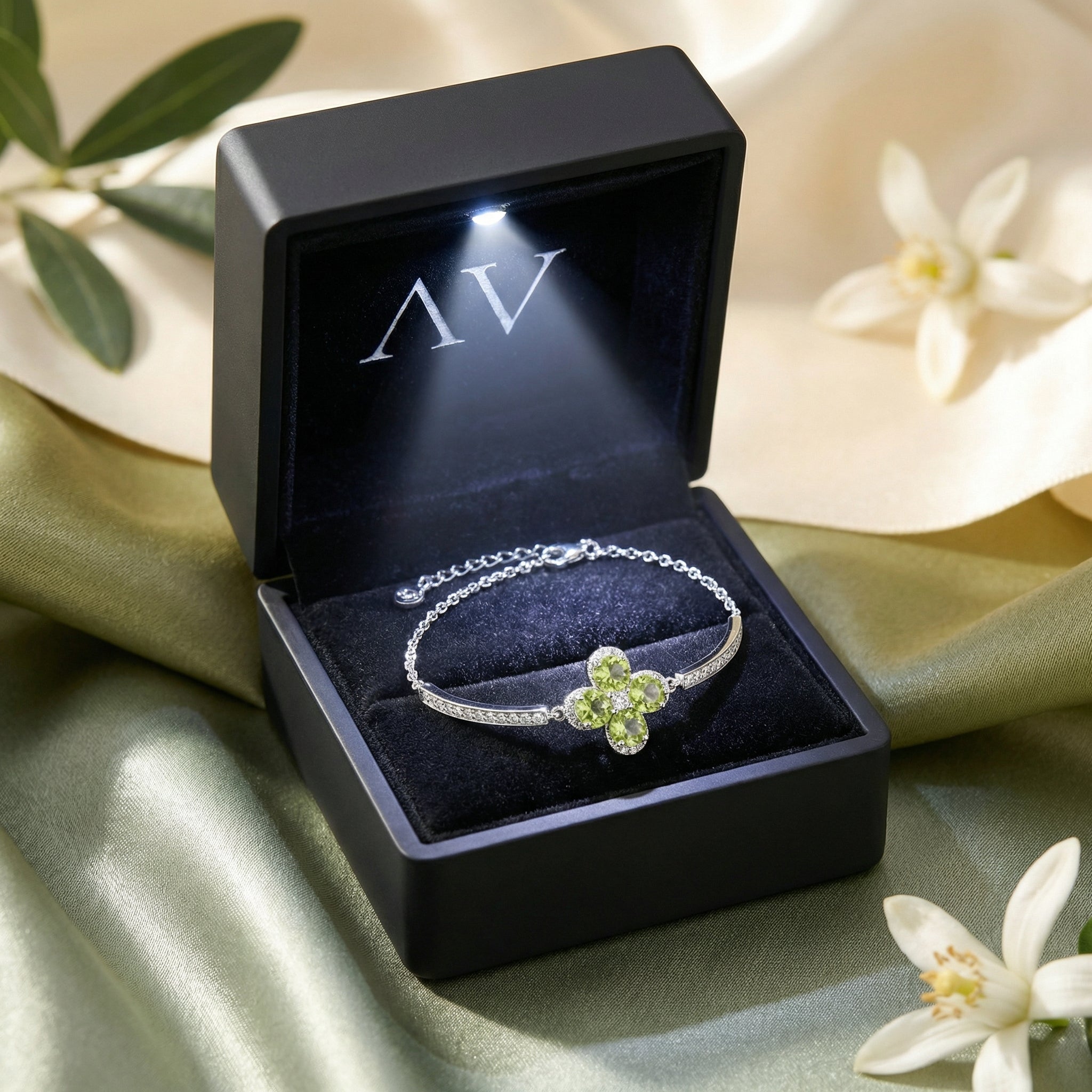 S925 sterling silver peridot station bracelet presented in a black lighted gift box on silk fabric.