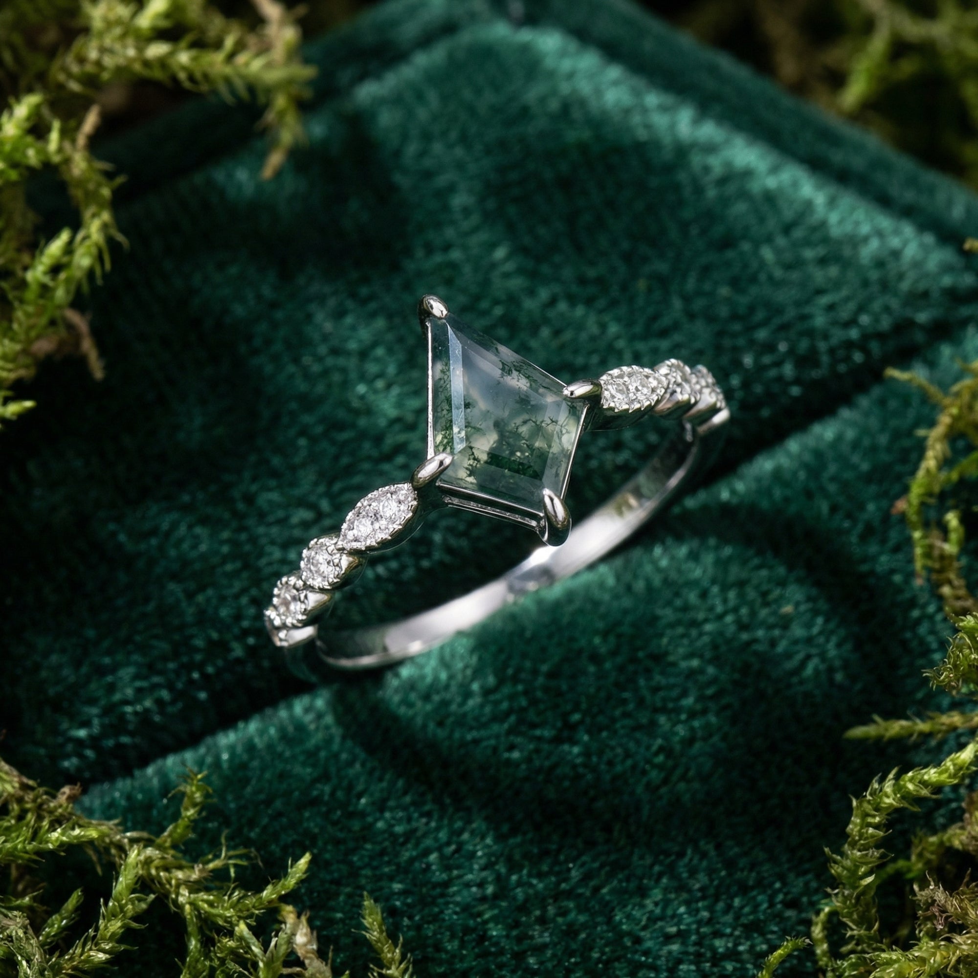 Kite cut moss agate ring in S925 sterling silver with diamond accents on a green velvet and moss background.