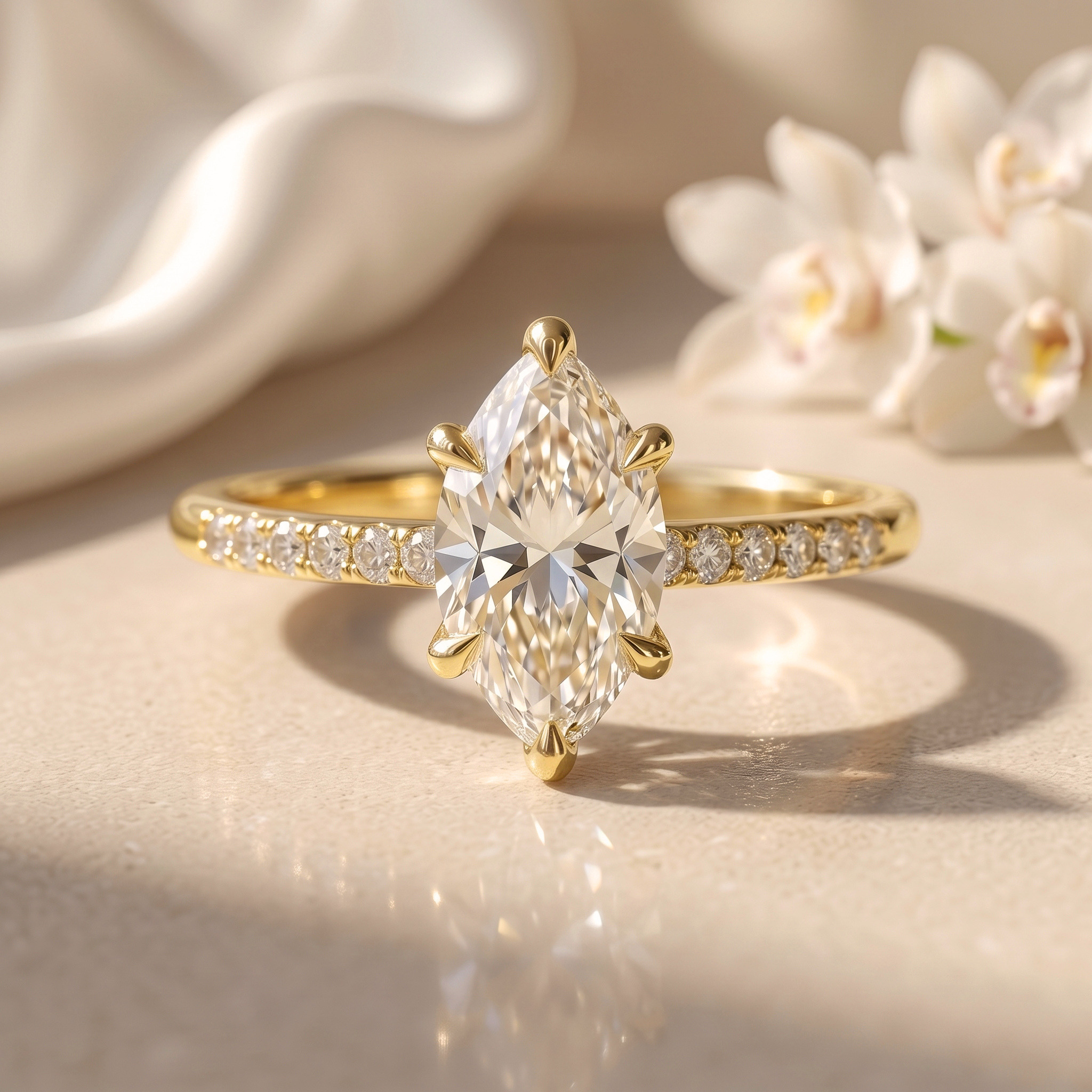 A stunning yellow gold engagement ring featuring a brilliant marquise-cut moissanite center stone held by six prongs on a sparkling diamond-accented band.