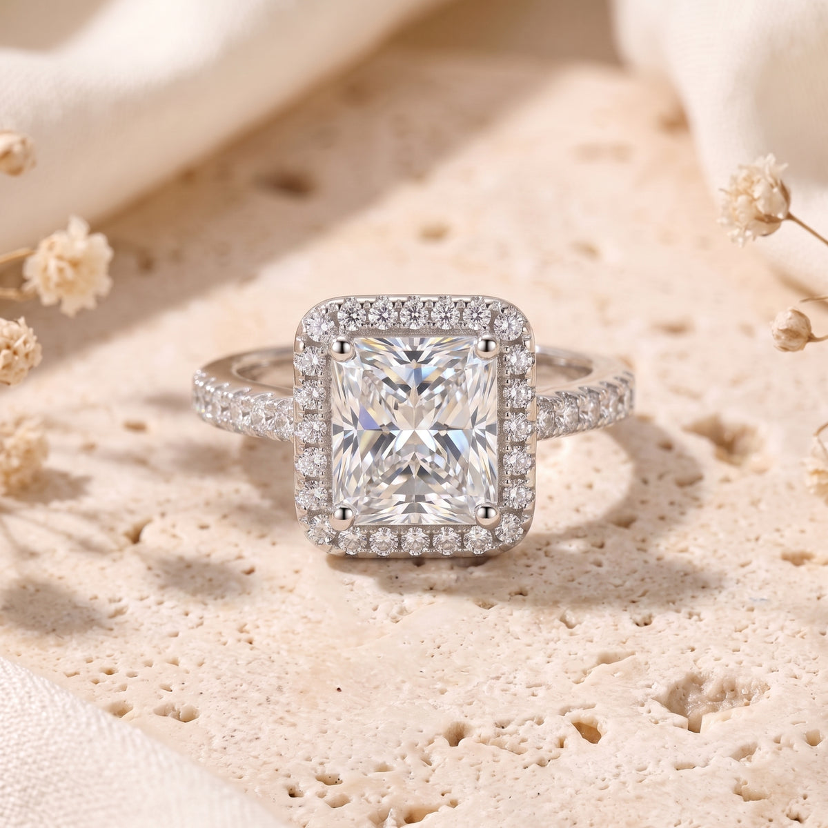 Front view of a radiant-cut cubic zirconia halo promise ring in sterling silver on a stone surface.