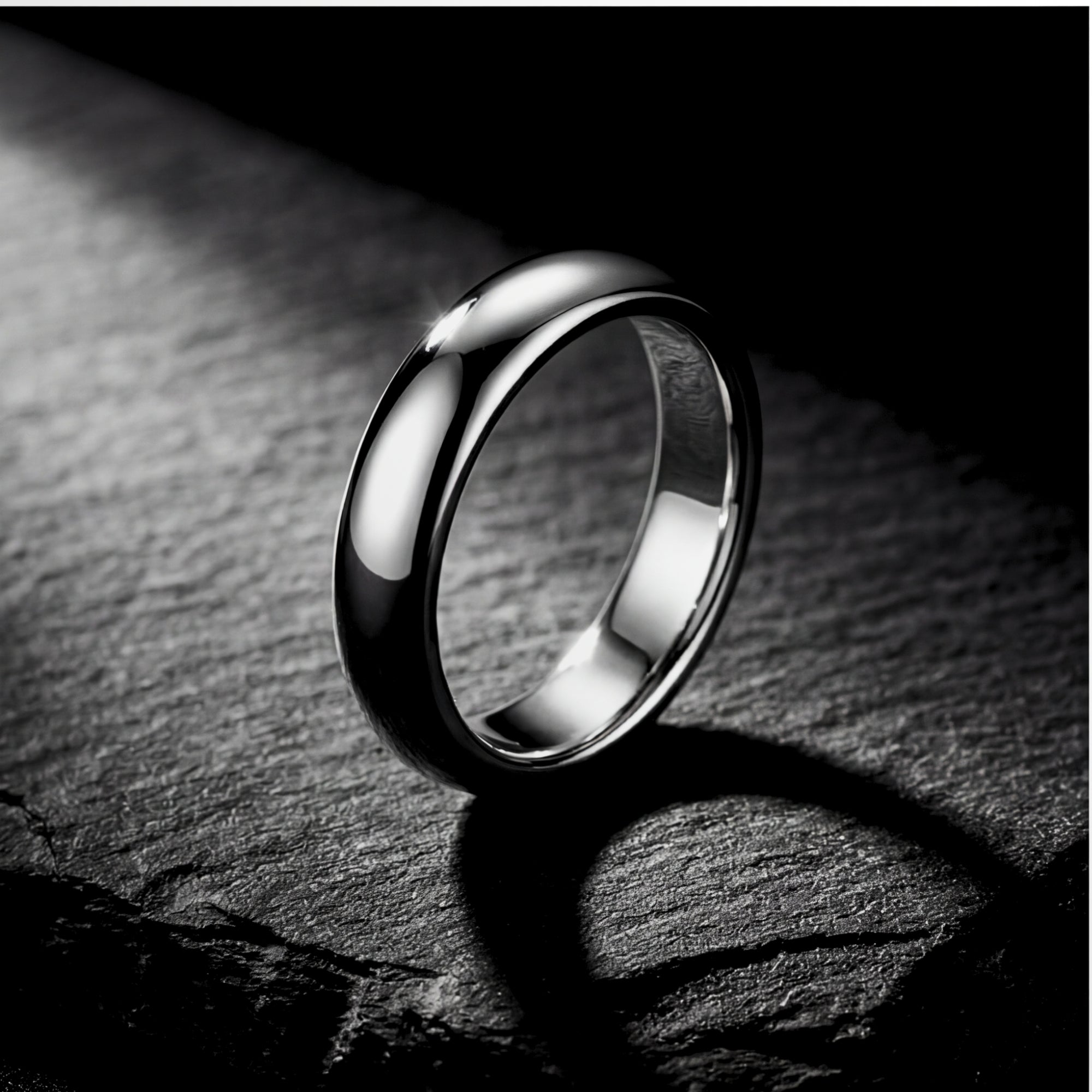 The Minimalist Ring, a silver 5mm stainless steel band for men, standing on a dark textured stone surface.