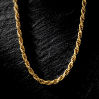4mm gold rope chain in stainless steel displayed on a dark textured stone background.