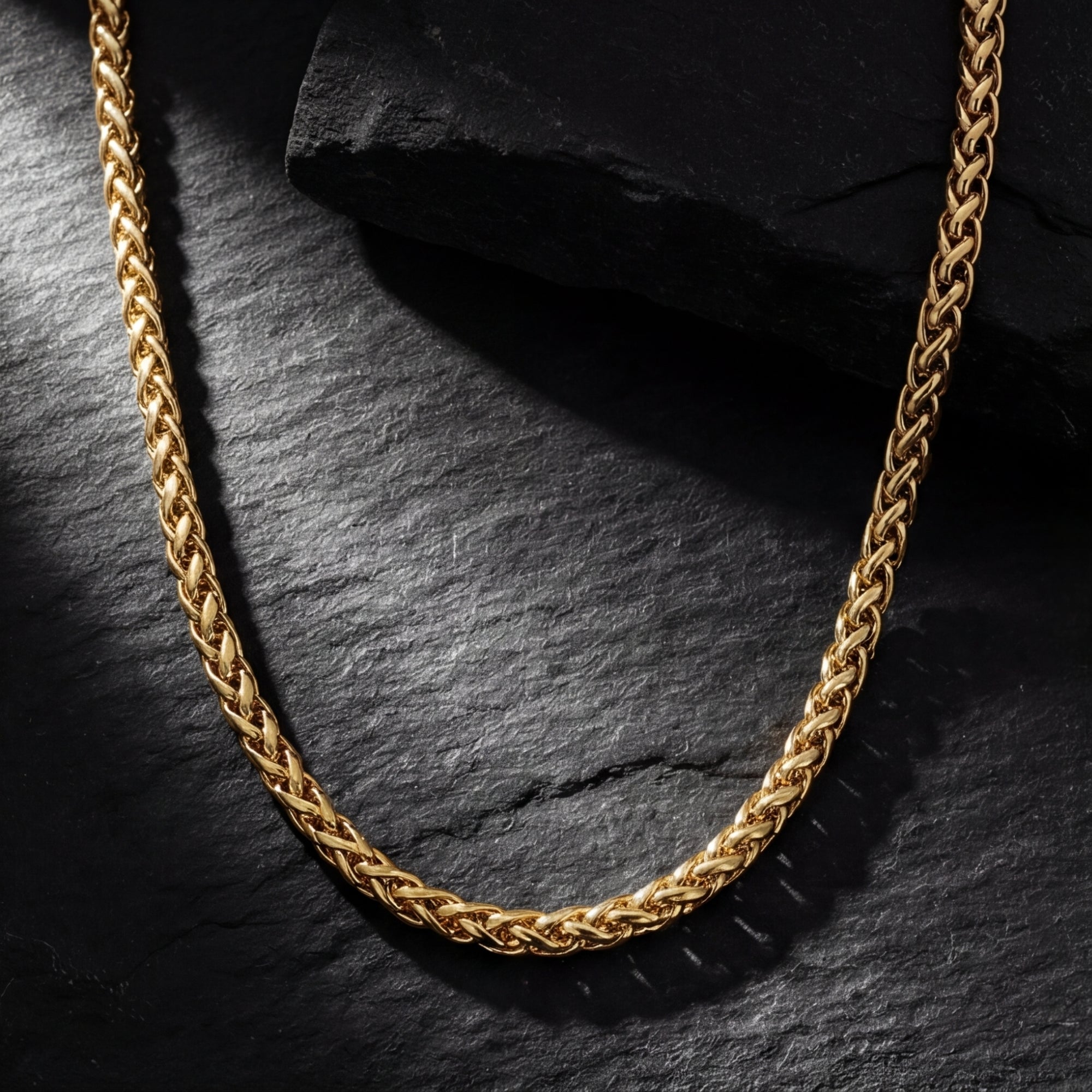 6mm gold stainless steel wheat chain displayed on a dark textured stone background.
