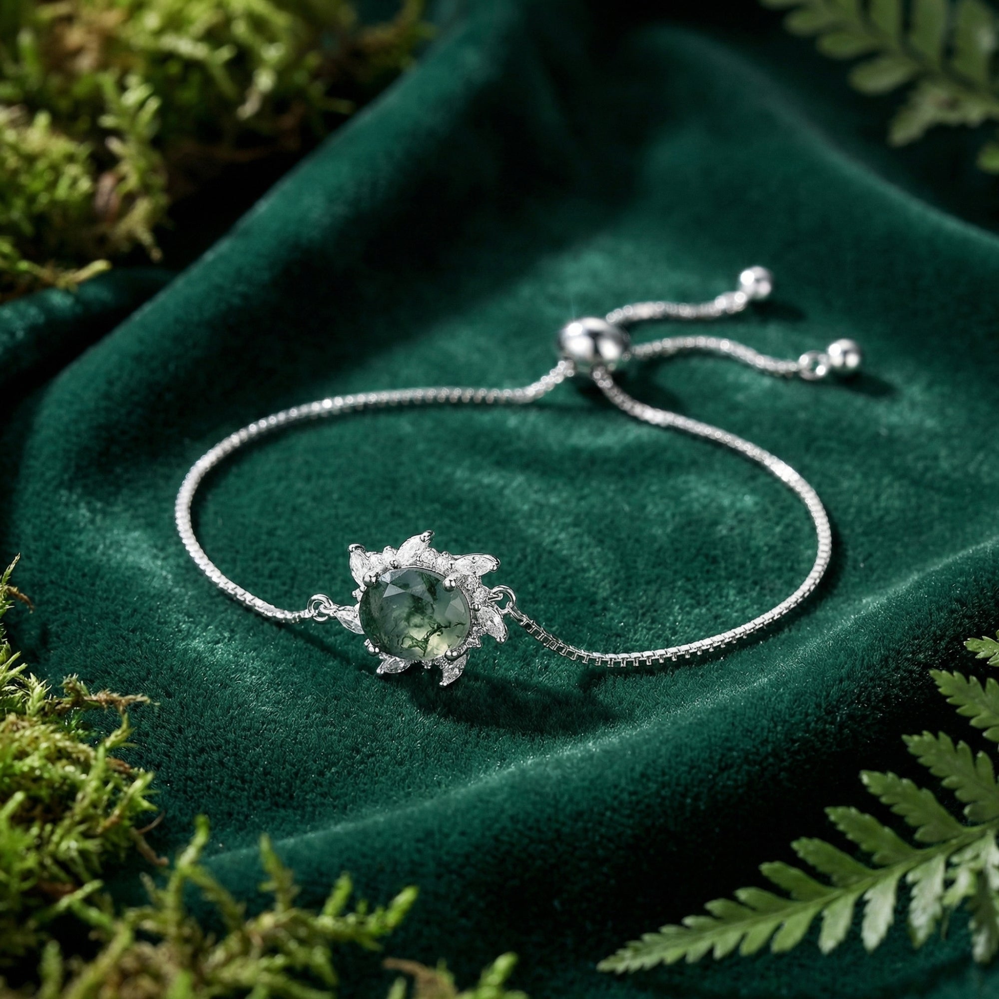 Sunburst natural moss agate bracelet in S925 sterling silver on a green velvet background with moss.