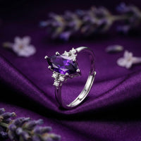 Marquesa cut natural amethyst ring in solid white gold, angled front view on purple silk with lavender sprigs.
