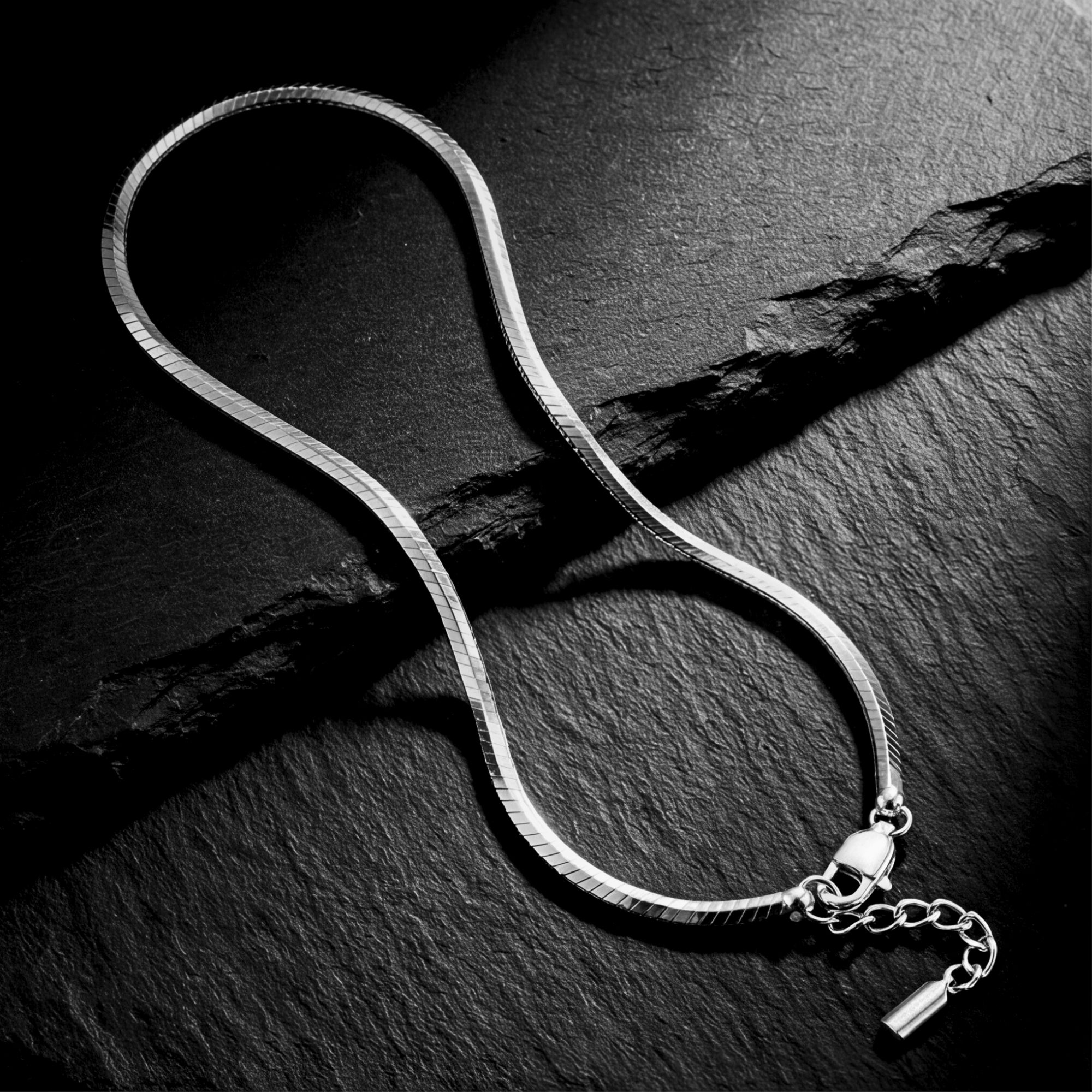 Silver stainless steel octagon link bracelet displayed on a dark textured stone surface.