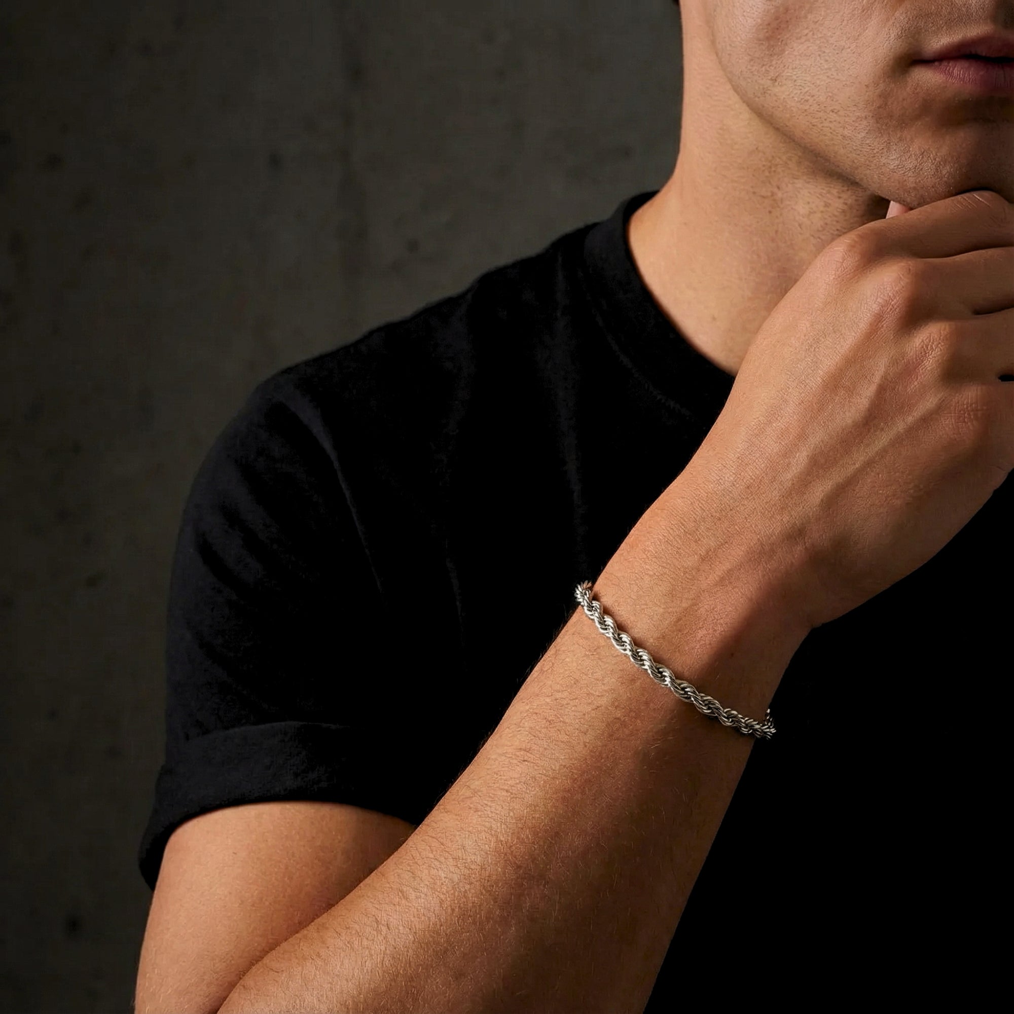 Men's silver stainless steel mariner rope bracelet worn on a wrist, styled with a black t-shirt.