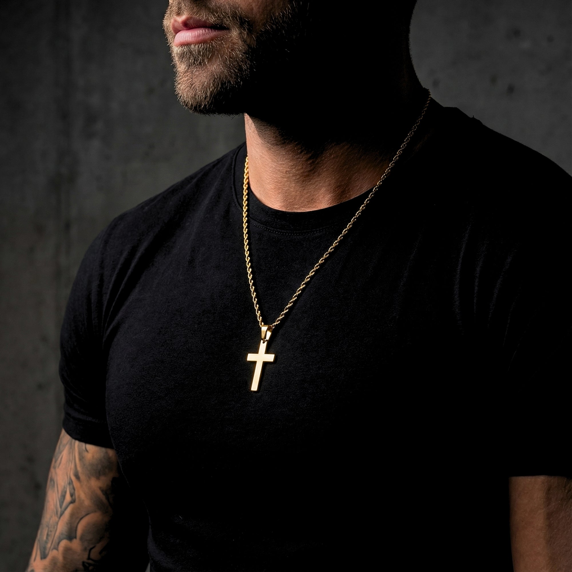 Side profile of a man wearing the gold Apostle Cross pendant on a rope chain with a black t-shirt.