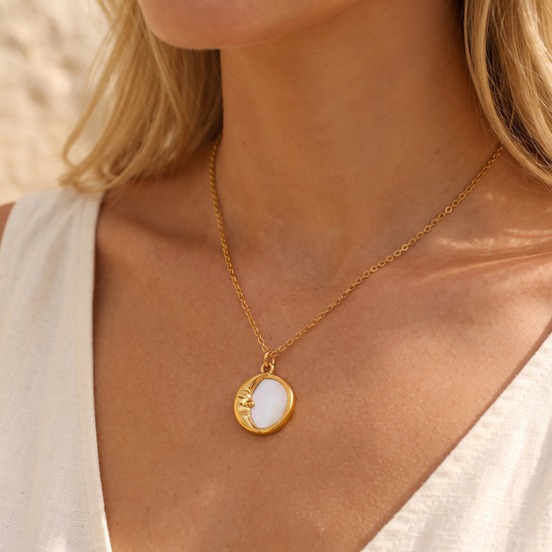 Model wearing the gold-tone crescent moon pendant necklace with a white sleeveless top.