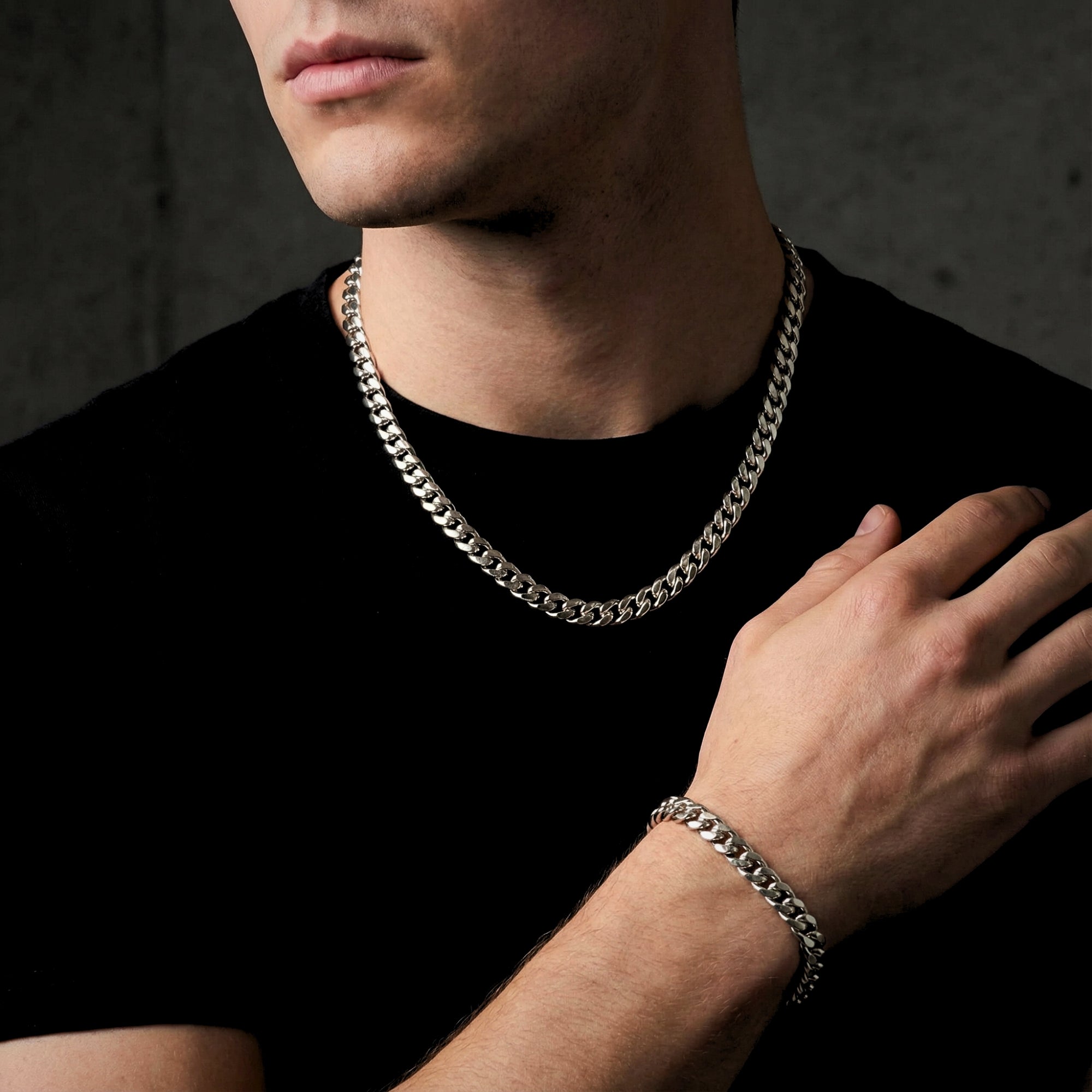 Model wearing the silver stainless steel Cuban link chain and matching bracelet set with a black t-shirt.