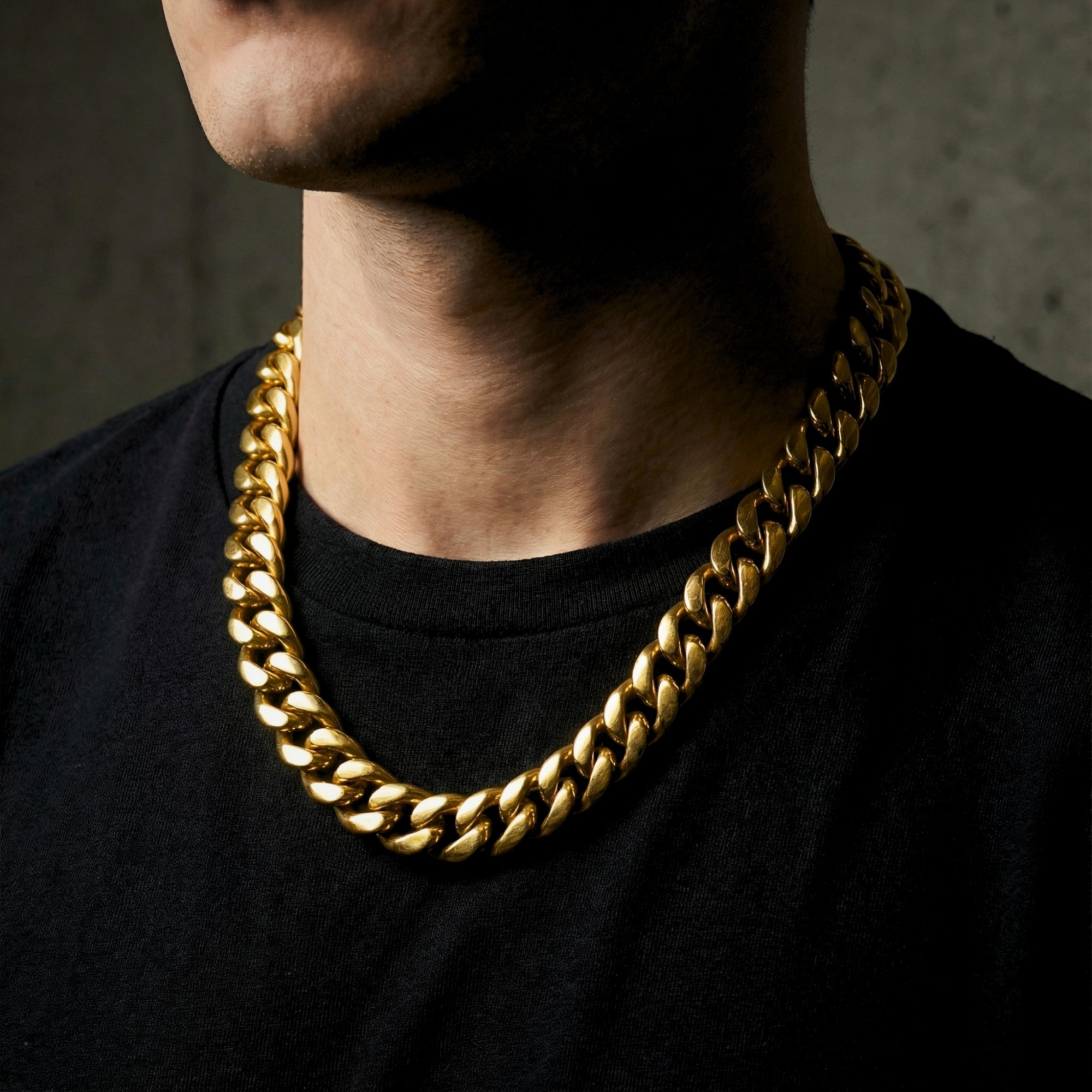 Front view of a man wearing the 12mm gold stainless steel Emperor Cuban link chain over a black t-shirt.