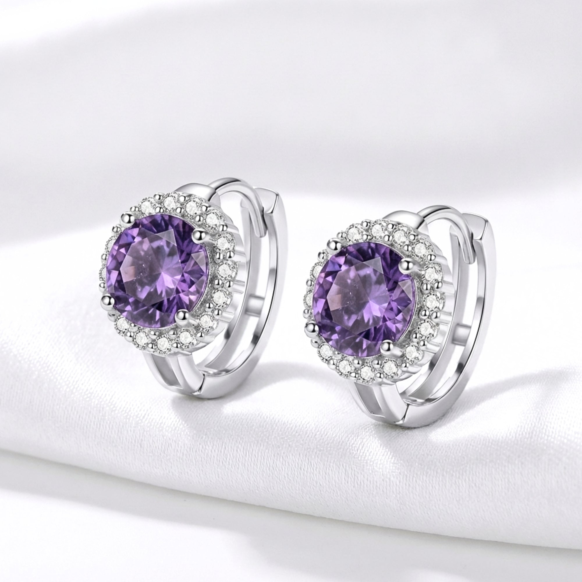 Angled view of round cut purple moissanite halo earrings in S925 sterling silver with leverback closures.