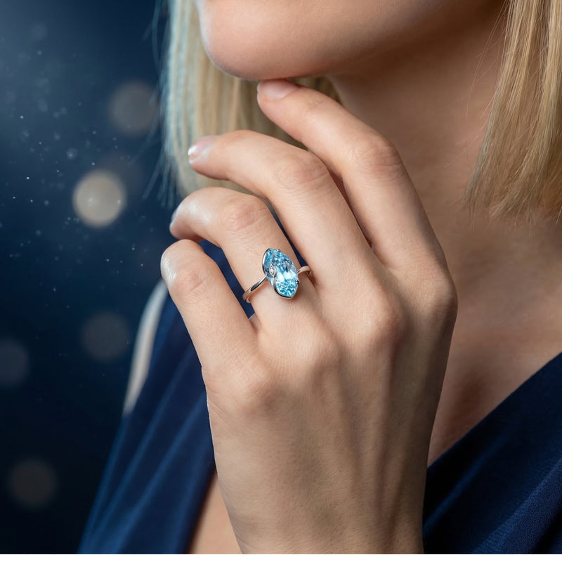Marquise cut natural blue topaz sterling silver ring worn on a woman's hand.