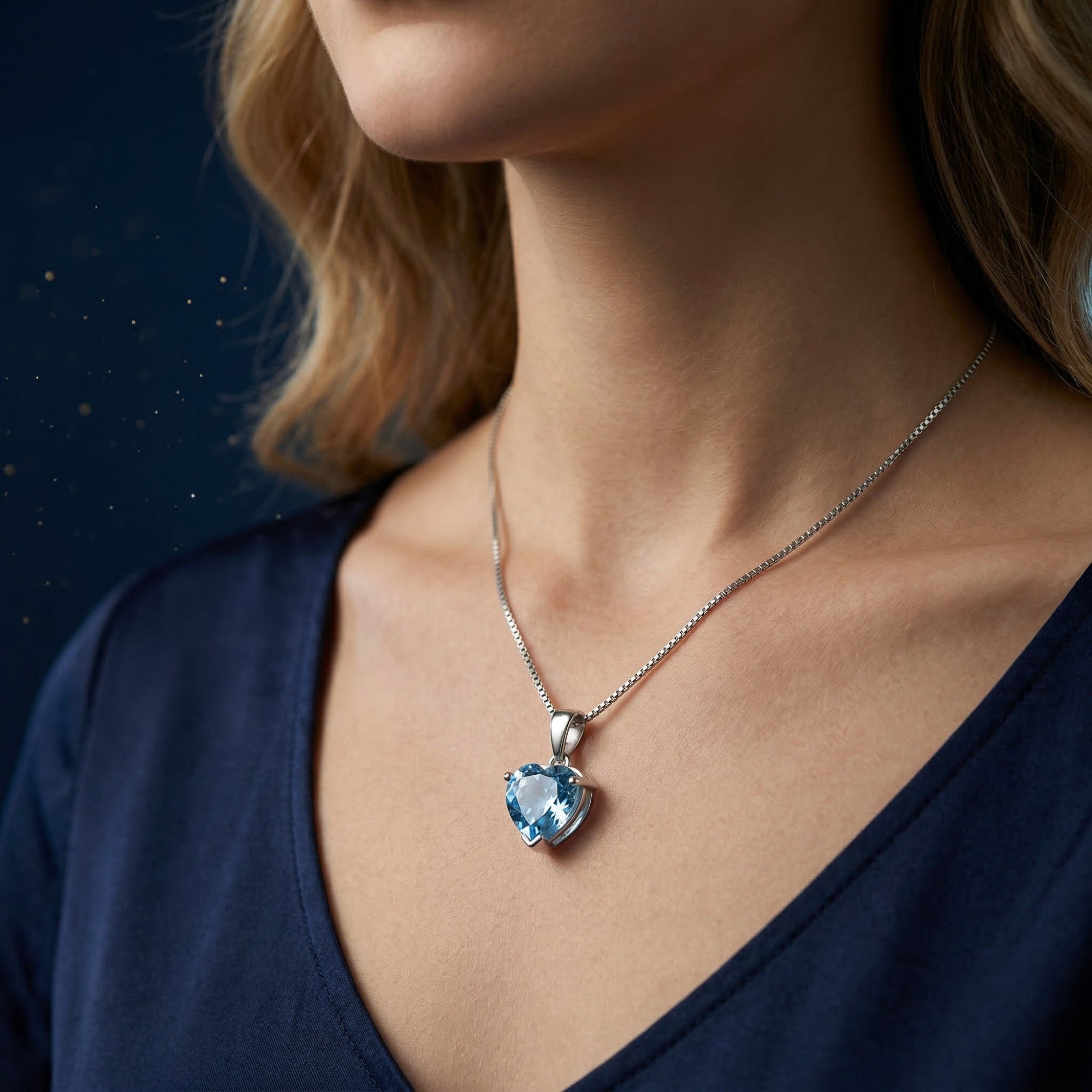 Side view of a model wearing the heart-cut natural blue topaz necklace in white gold.