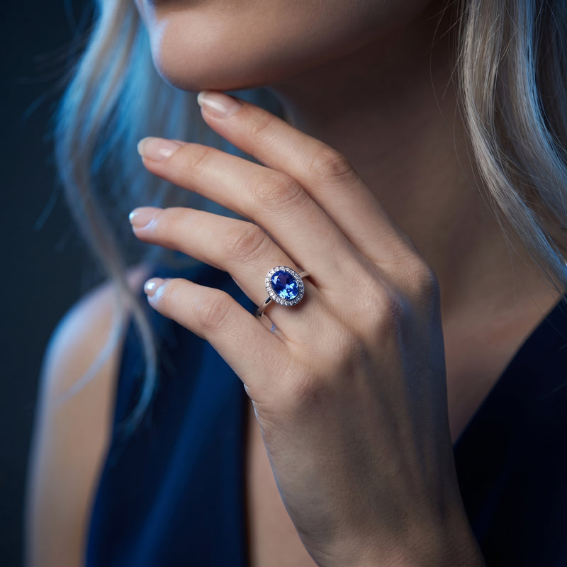 Model wearing the Lirael 18K white gold oval tanzanite and diamond halo ring.