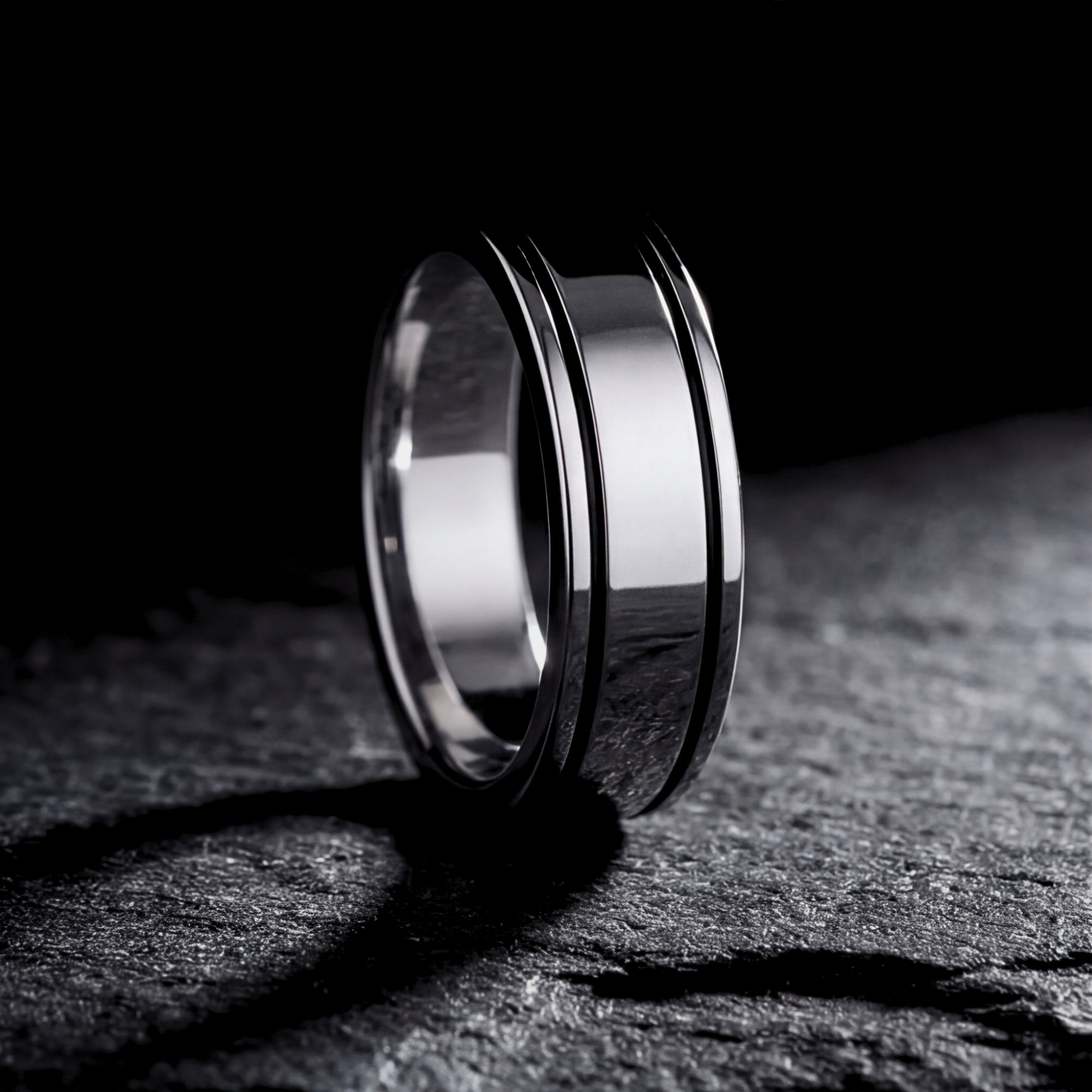 Side profile of the silver stainless steel Horizon band ring resting on a dark slate background.