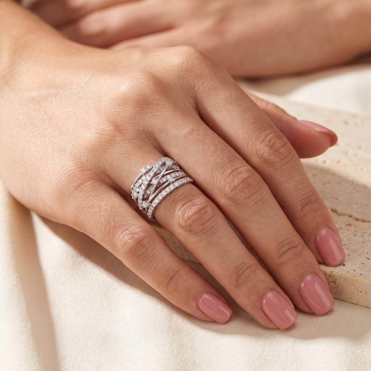 Full hand view of the Aria multi-band criss-cross ring in solid white gold with A5 Cubic Zirconia worn on the ring finger.