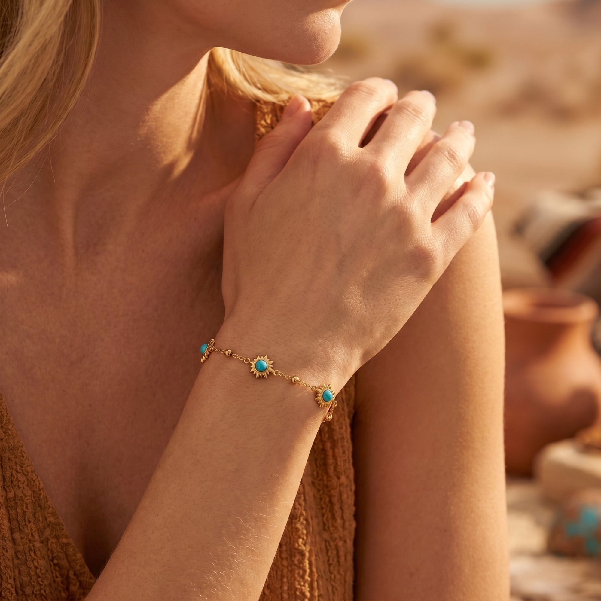 Woman wearing the gold Palo Verde turquoise sunburst bracelet on her wrist in a desert setting.