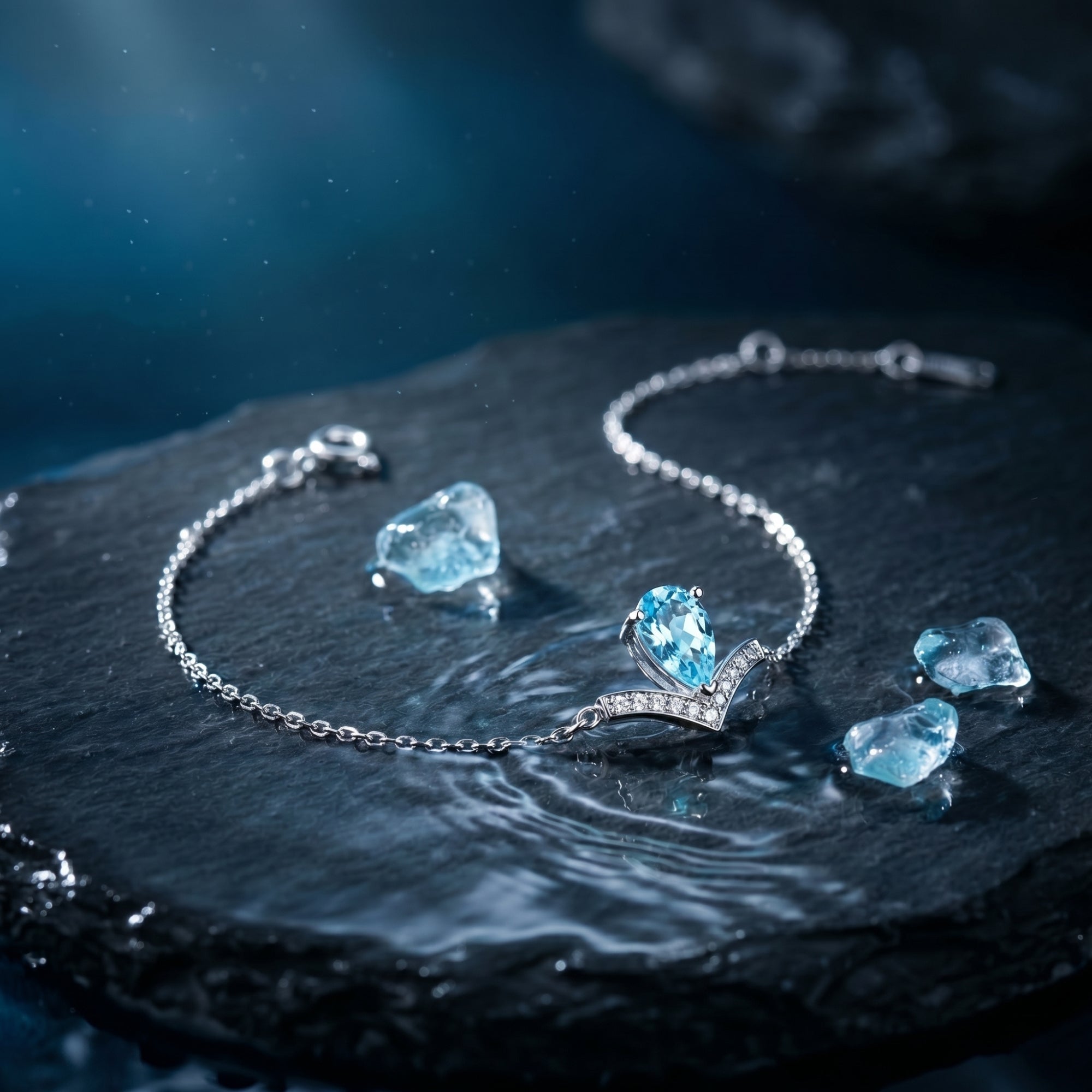 Pear-cut natural aquamarine Pt950 platinum bracelet with diamond accents curved on a dark rock with raw aquamarine.