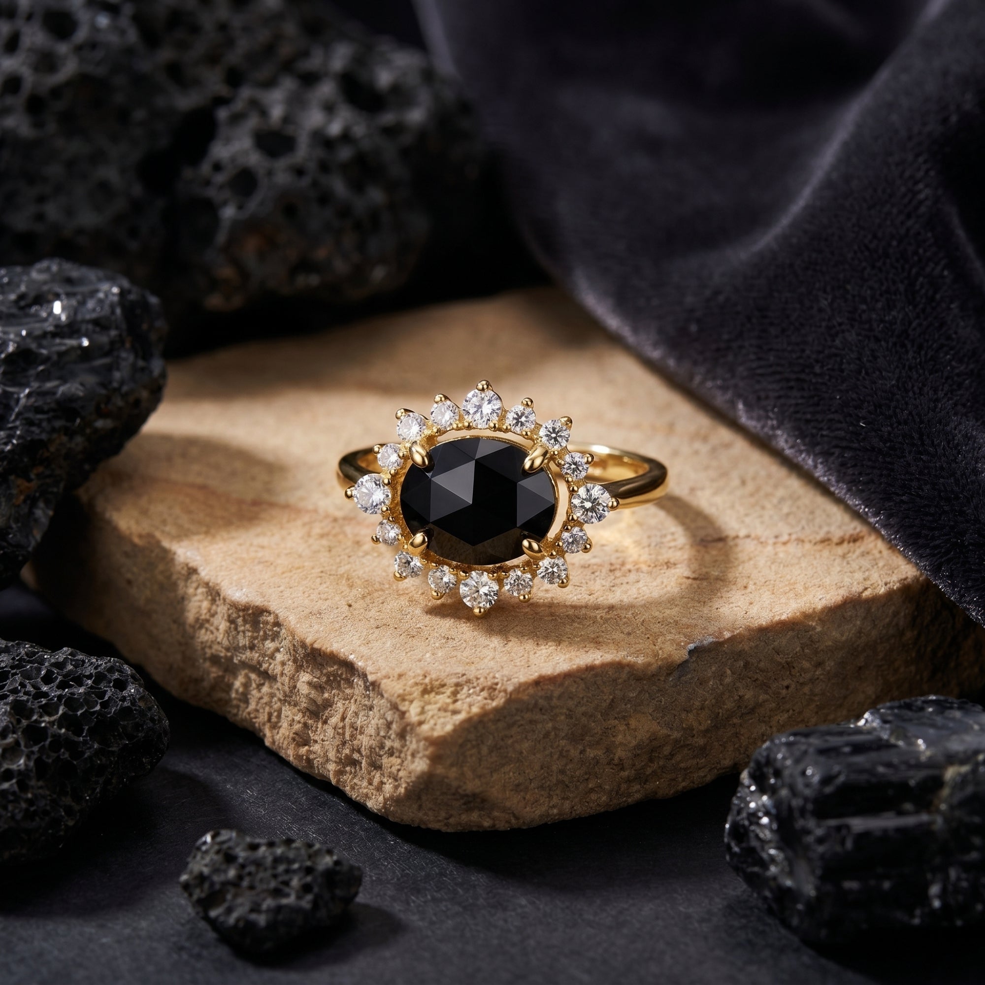 Front view of the 18K gold plated Aurelius ring featuring an oval-cut black onyx and halo on a stone slab.