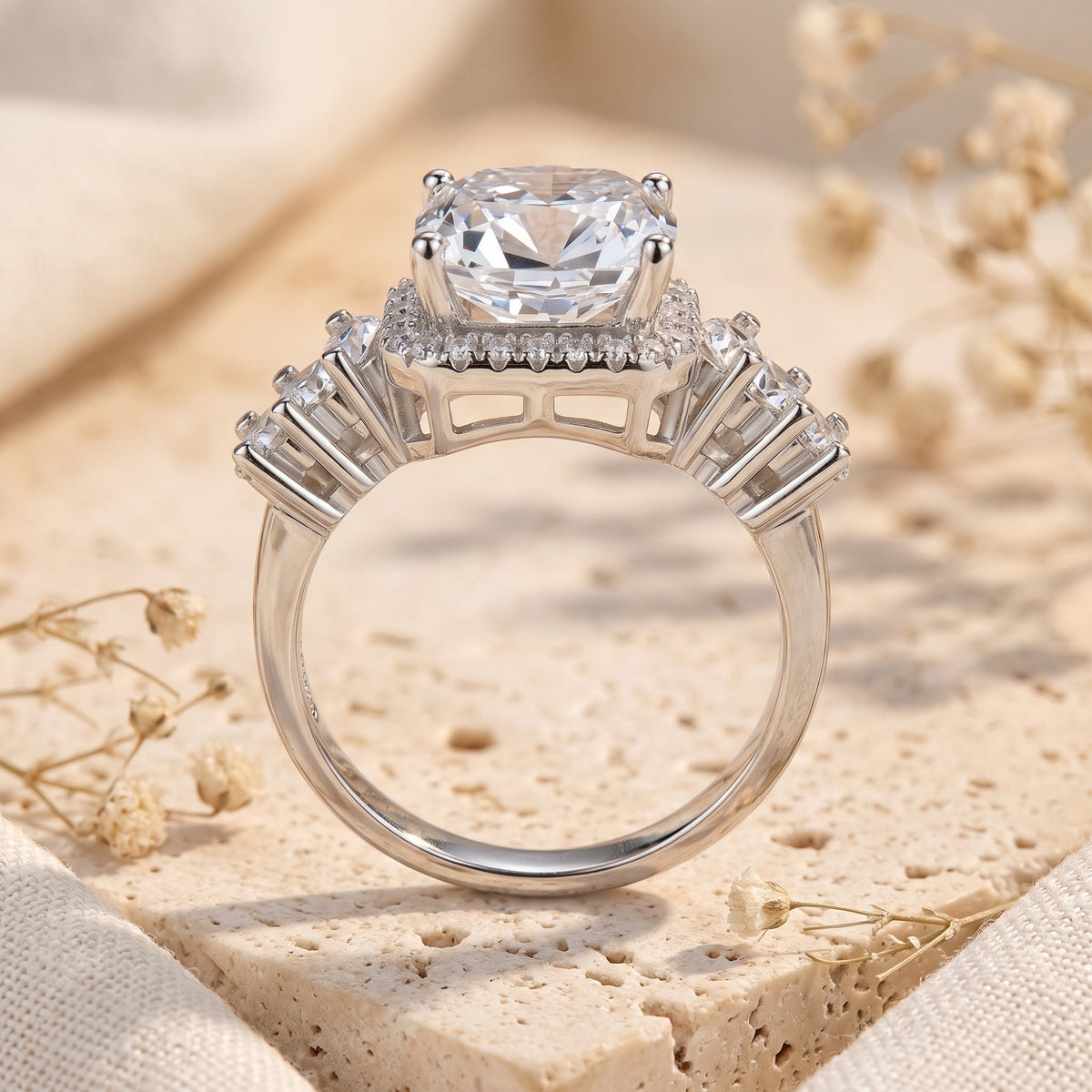 Side profile view of the silver halo ring standing upright, showing its openwork setting and side baguettes.