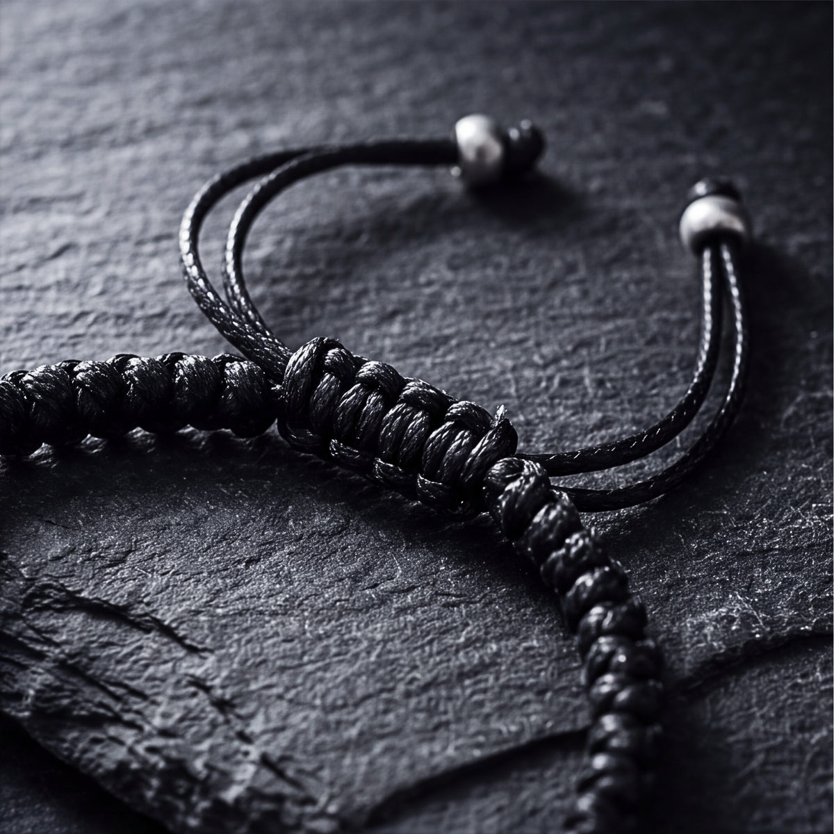 Close-up of the bracelet's adjustable sliding knot closure, cord, and silver end beads.
