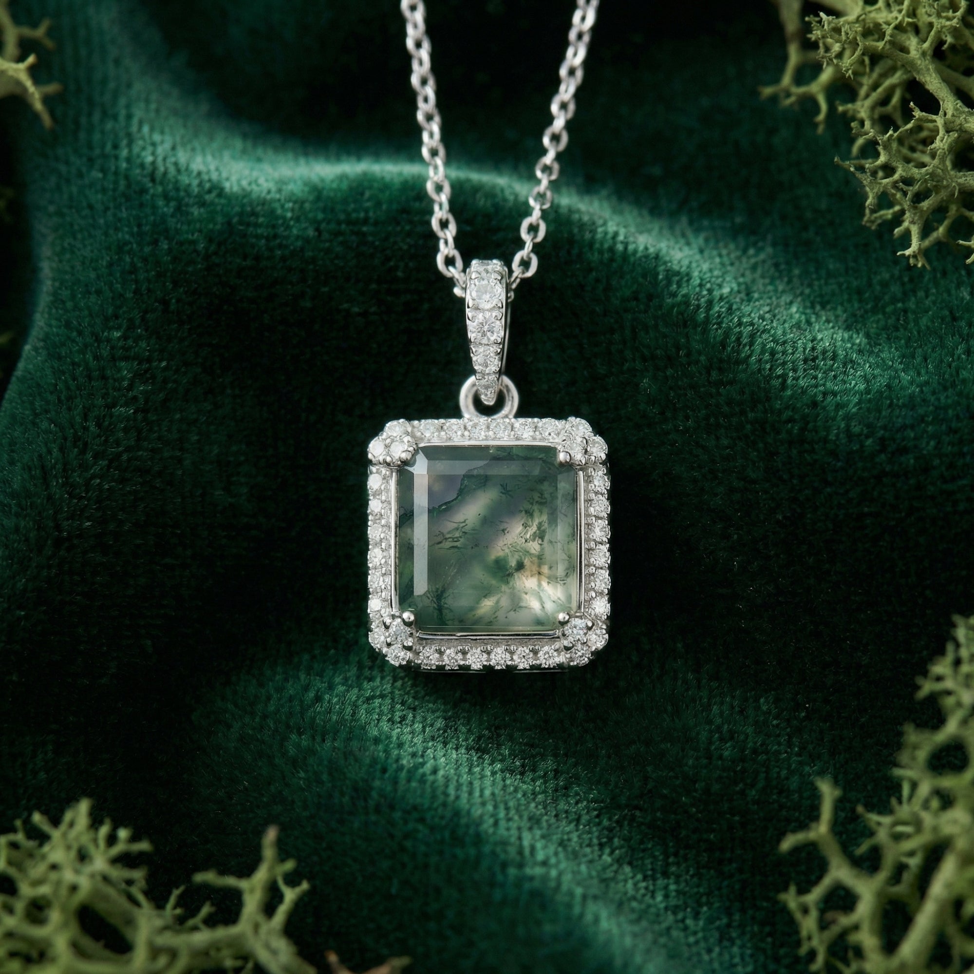 Close-up of a square cut natural moss agate pendant with a halo setting on a sterling silver chain.