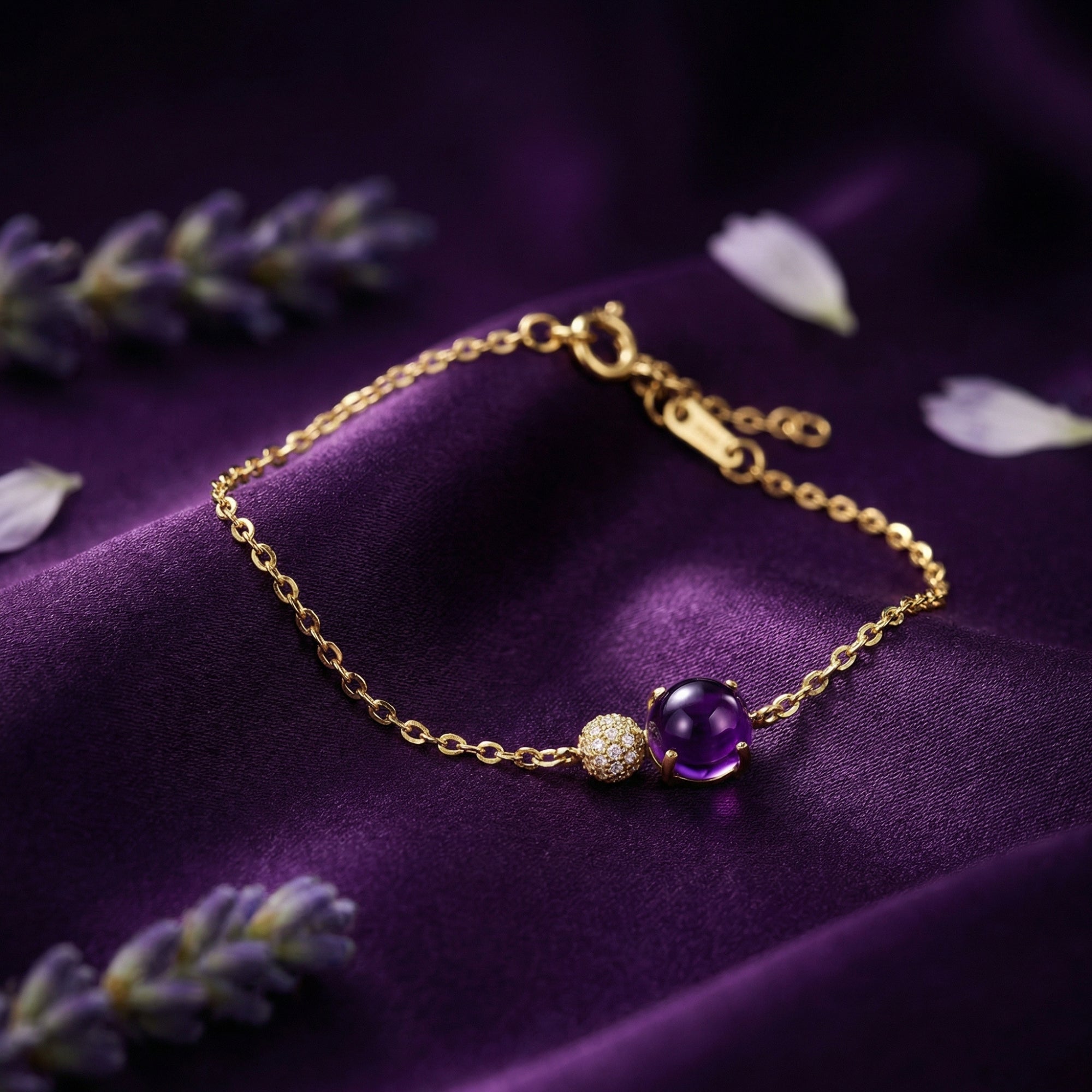 Close-up of the 18K yellow gold Veraline bracelet with a round cut amethyst and pavé bead on purple silk.