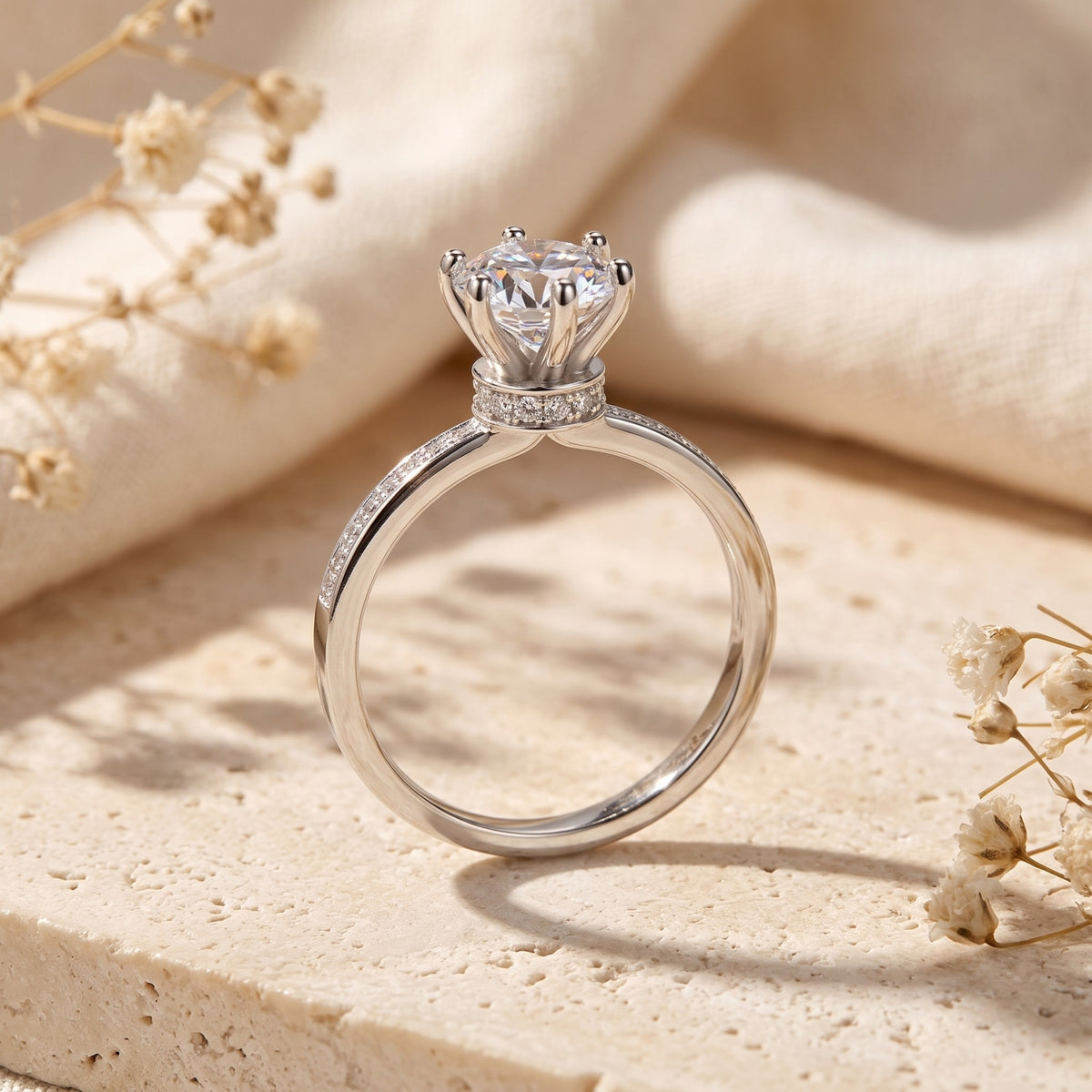 Side profile view of the silver ring, featuring an elevated six-prong crown setting with a clear center stone.