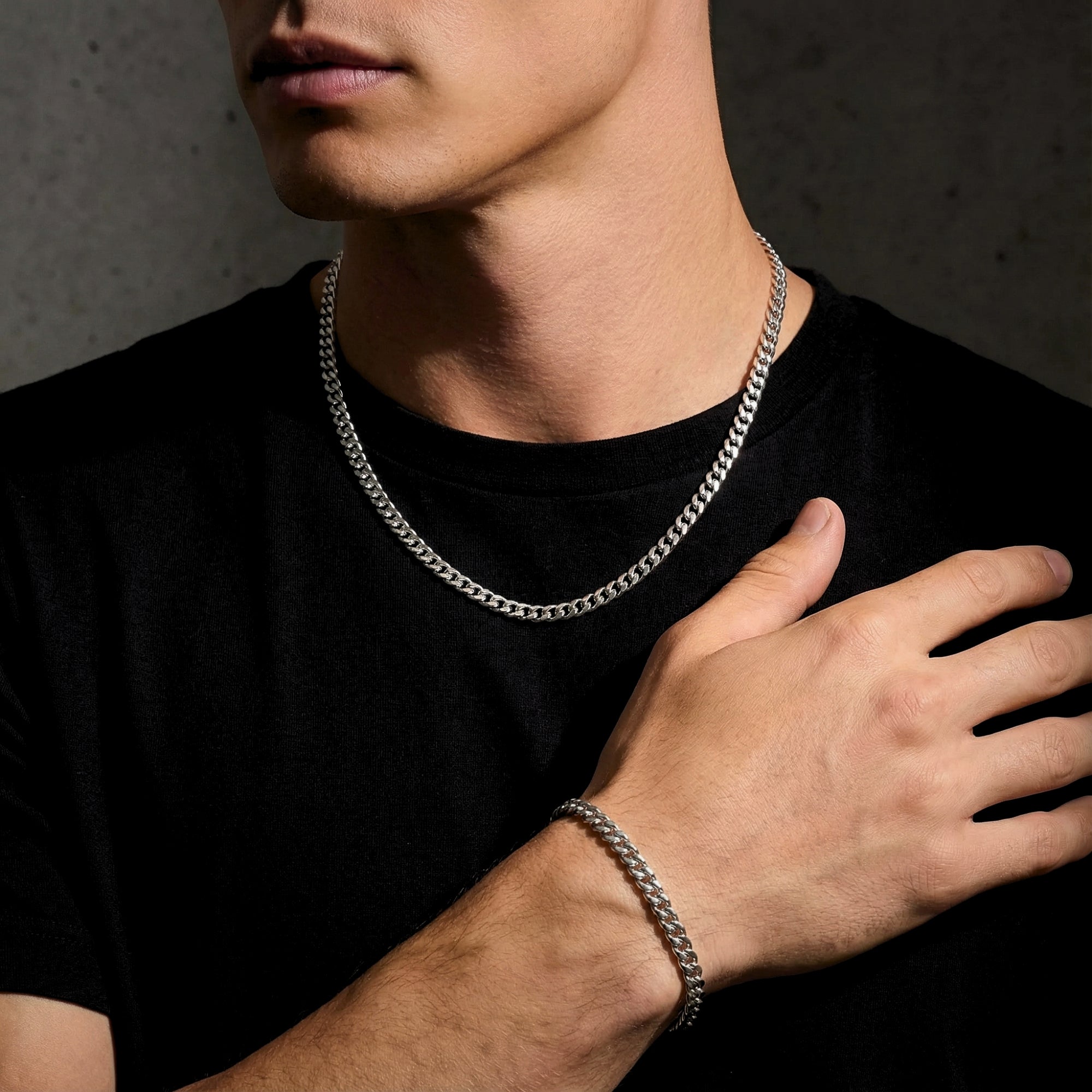 Man wearing a 6mm silver Cuban link chain and bracelet set with a black t-shirt.