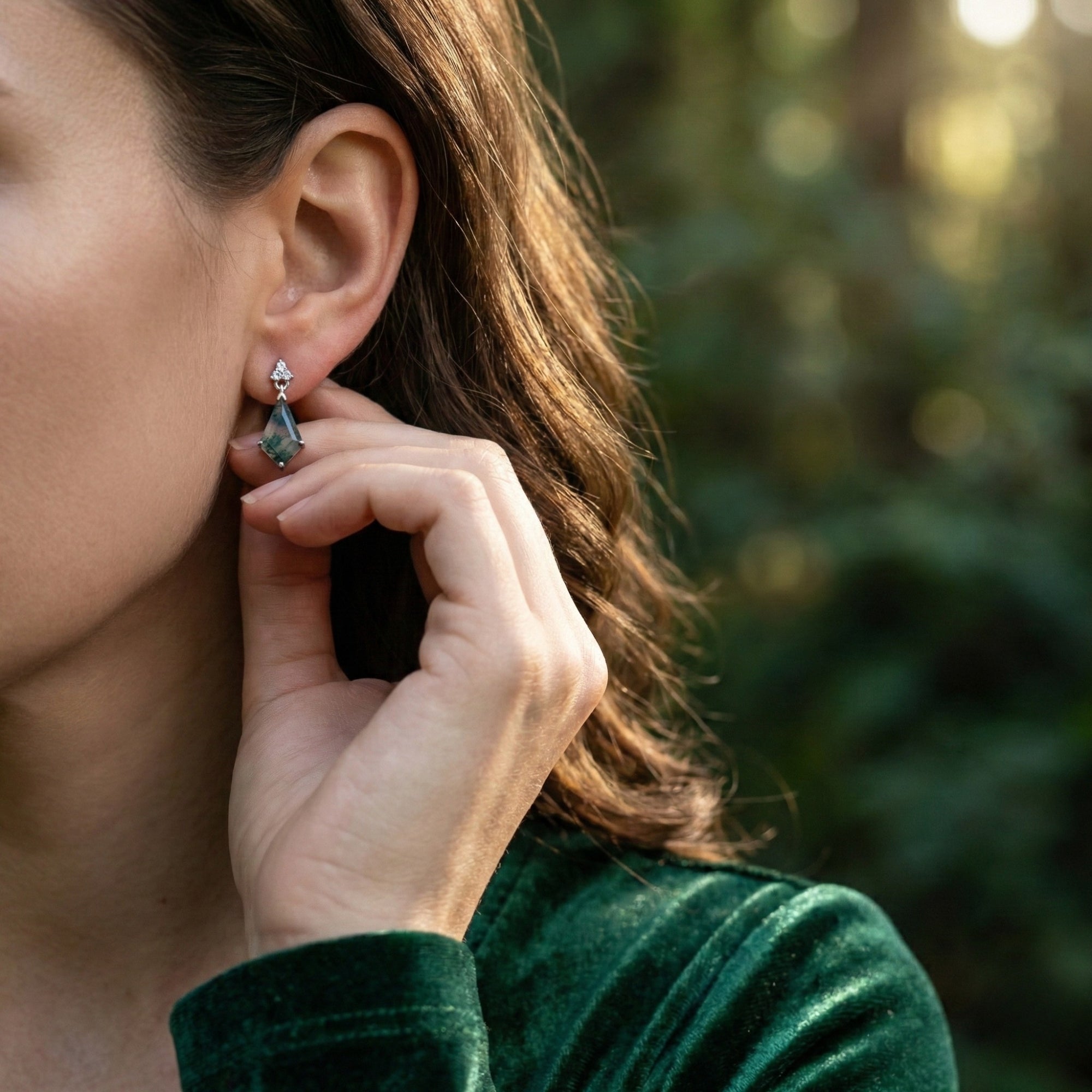 Model wearing a kite cut moss agate drop earring in sterling silver, with her hand visible for scale.