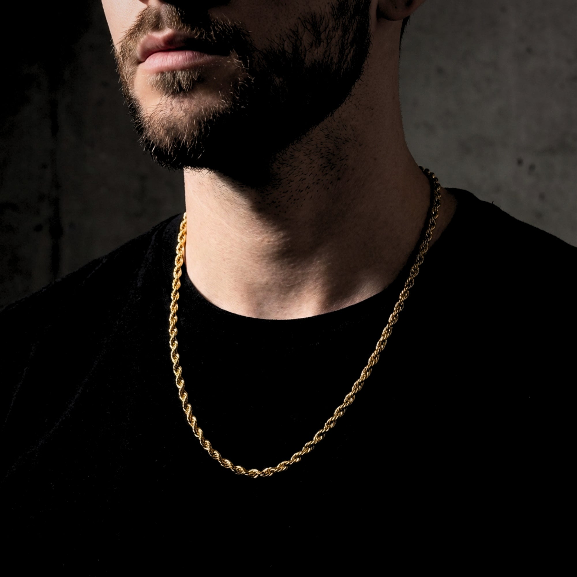 Men's 4mm gold stainless steel rope chain worn by a model over a black t-shirt.