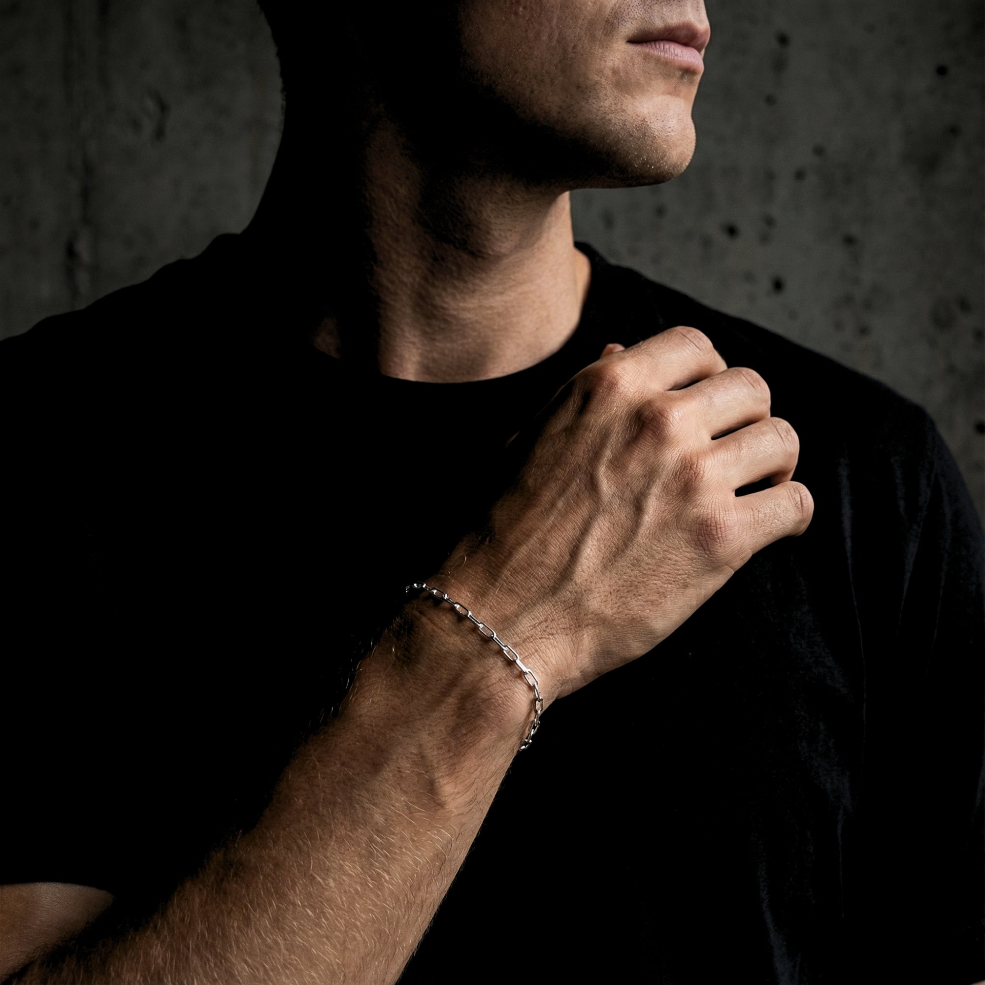 A man wearing the silver stainless steel clip chain bracelet, styled with a casual black t-shirt.