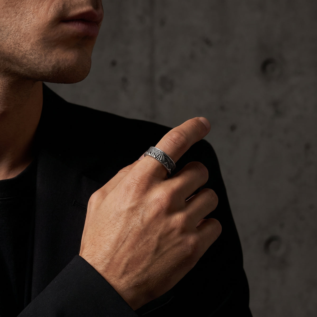 Man wearing the silver mountain ridge ring on his index finger with a black blazer.