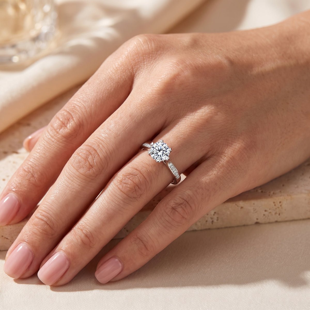 Hand model wearing the silver round-stone cathedral ring, shown from an angled top-down perspective.