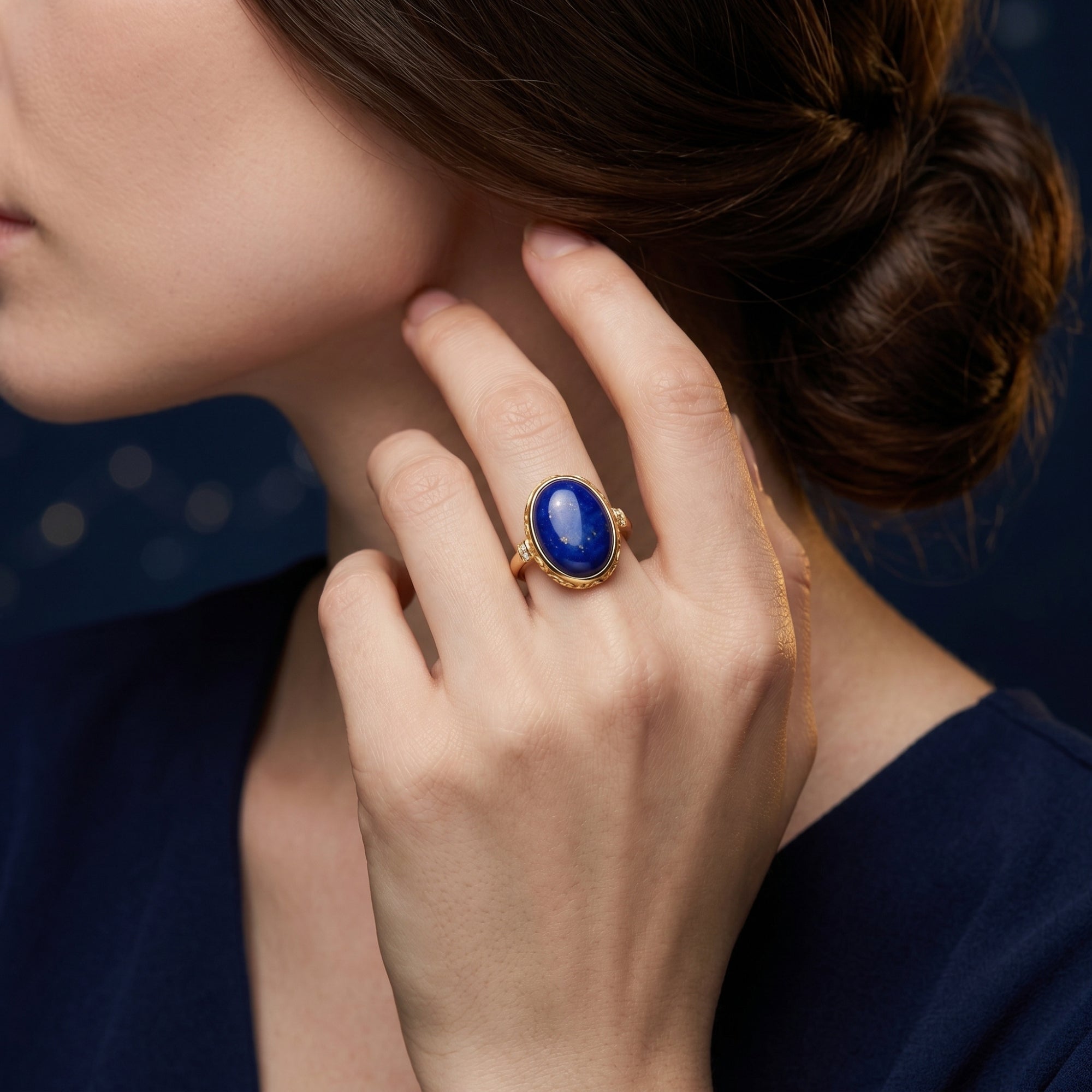 Model wearing the large oval lapis lazuli ring in yellow gold, showcasing the jewelry's scale on a woman's hand.