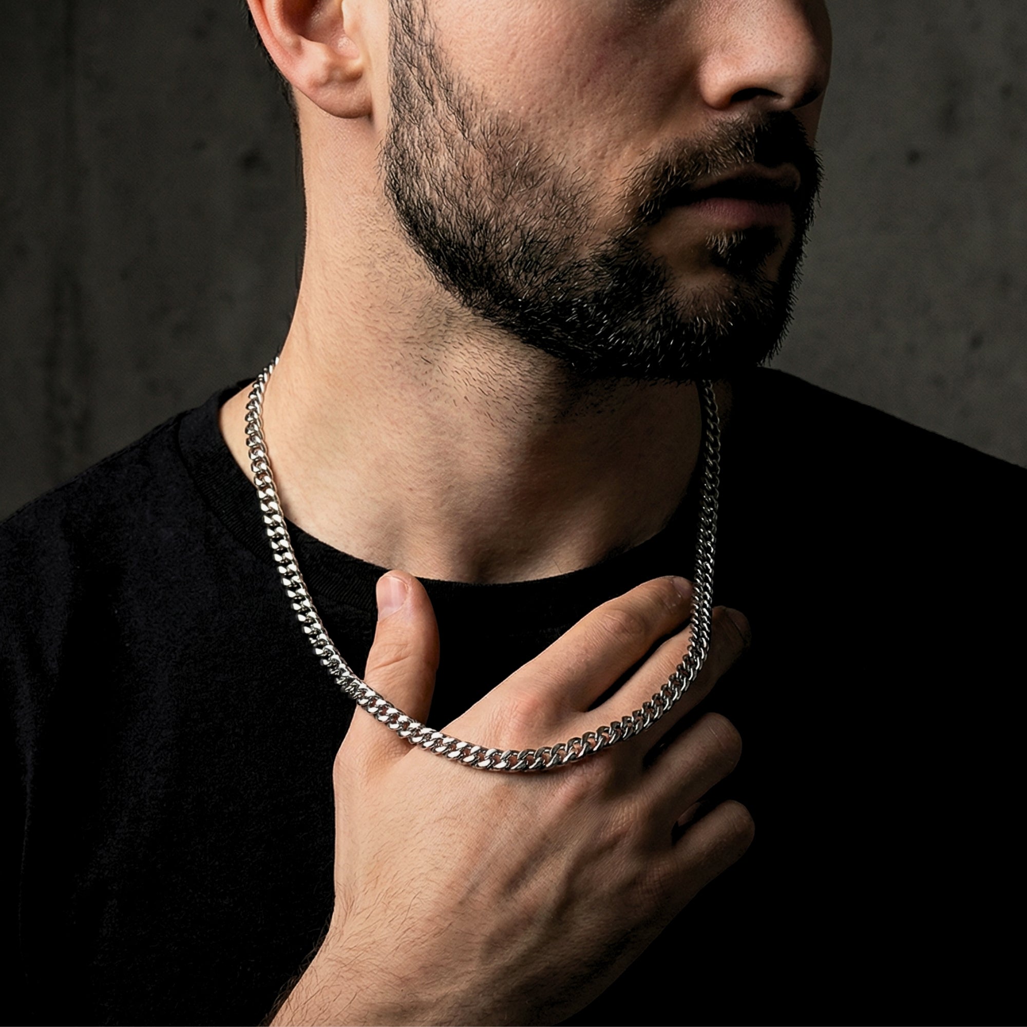Man holding a silver stainless steel Cuban link chain to show the 6mm width and scale.