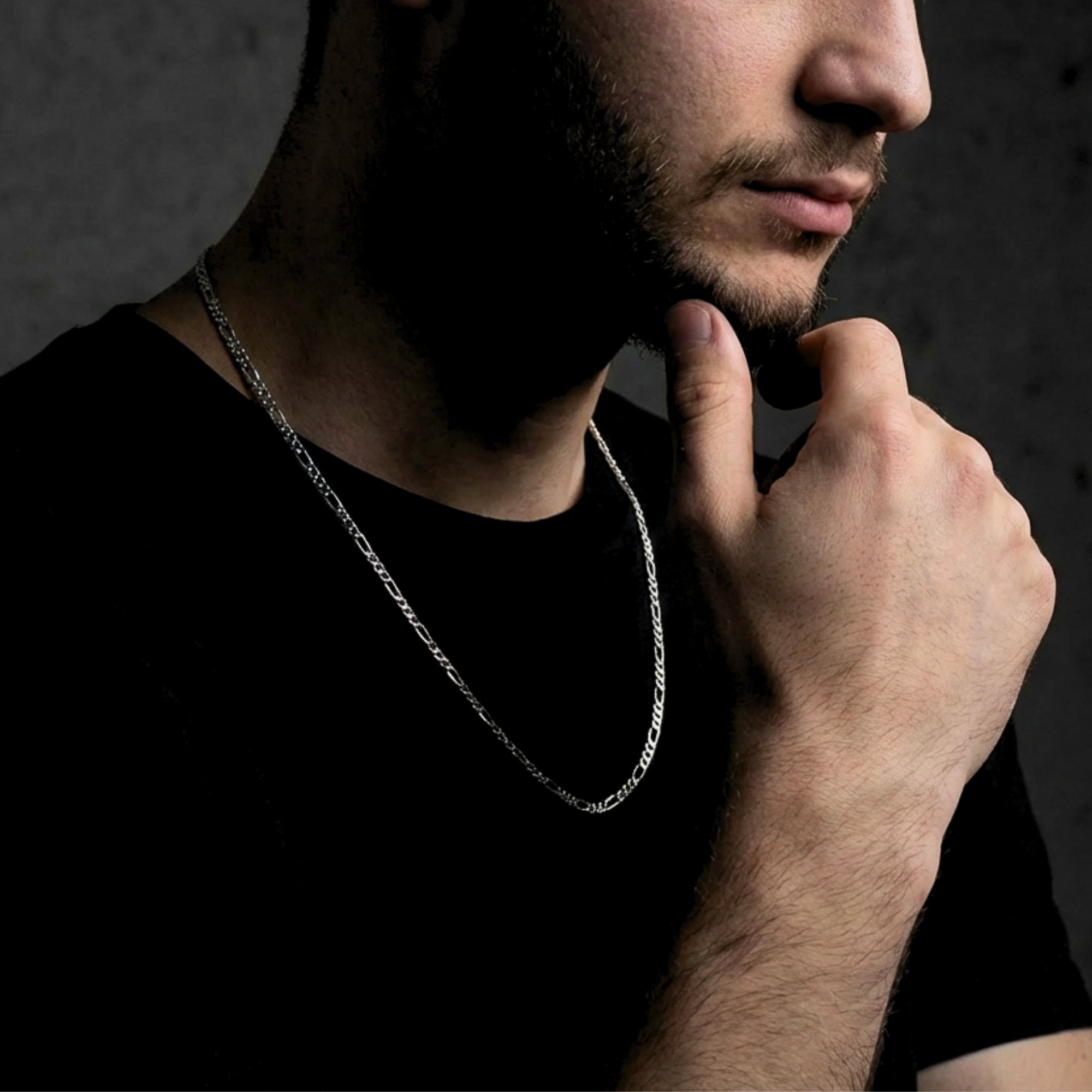 Side profile of a man wearing a 3mm silver stainless steel Figaro chain necklace.