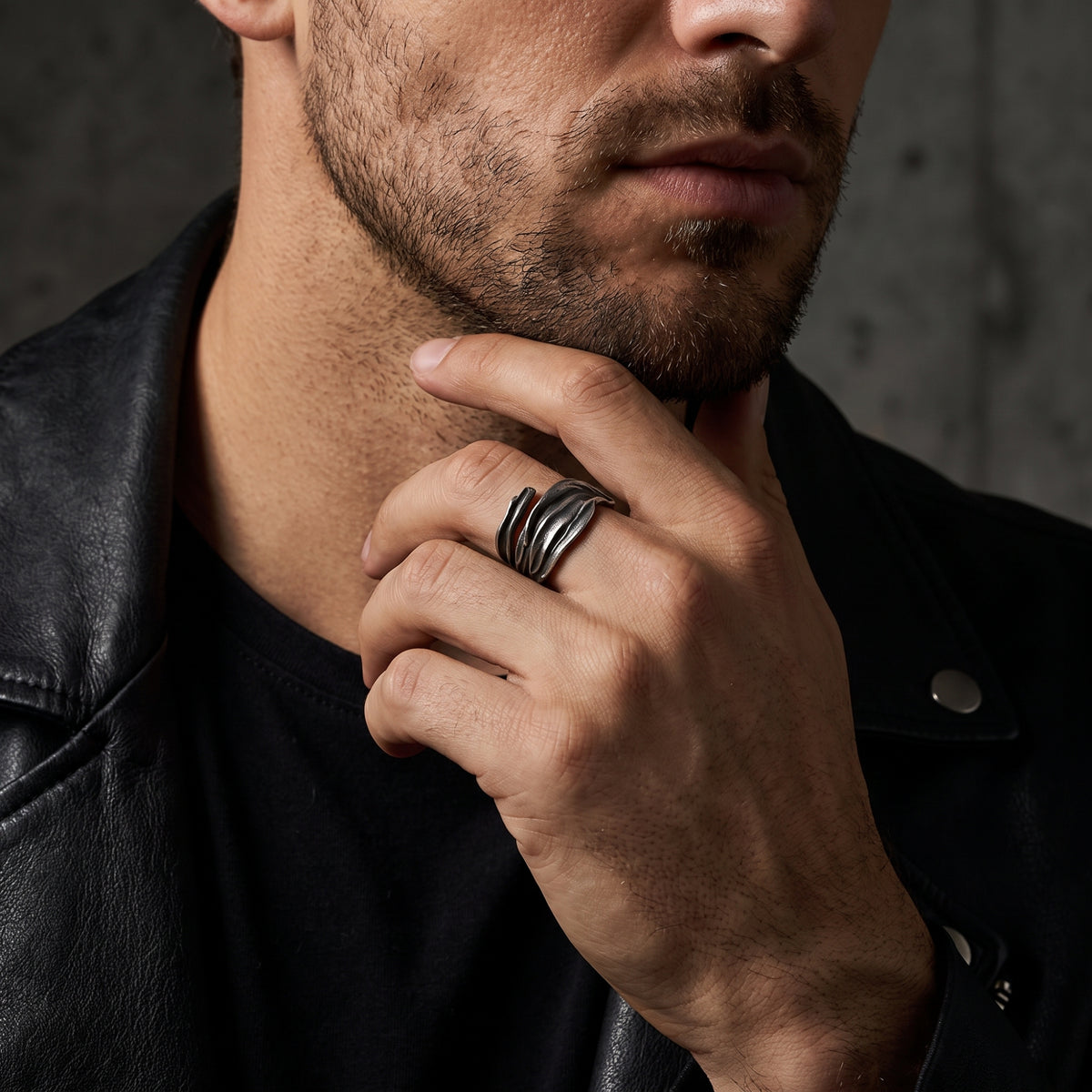 Man wearing the textured silver open wrap ring on his middle finger with a black leather jacket.