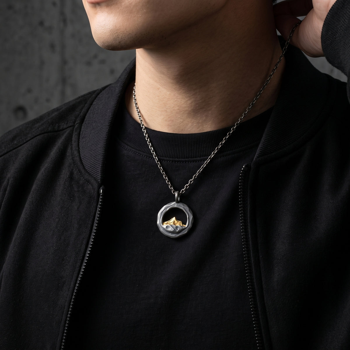 Male model wearing the silver mountain pendant necklace over a black T-shirt and jacket.