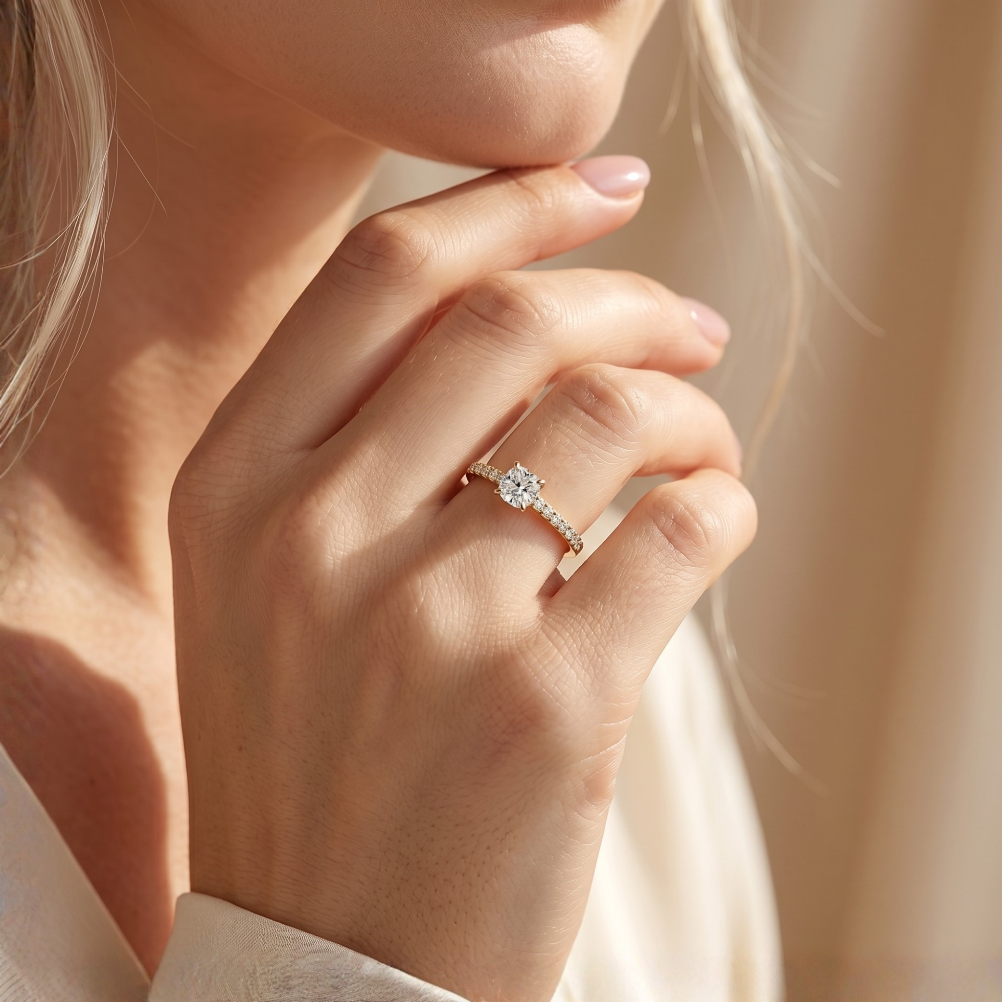 A lifestyle shot of a woman displaying the yellow gold cushion-cut moissanite engagement ring with a delicate pavé band on her hand.