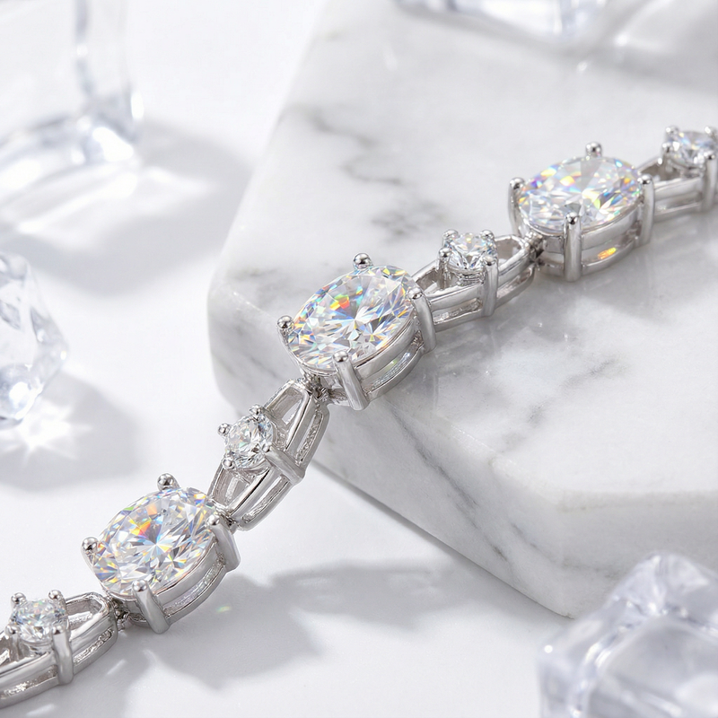 Macro view of oval and round simulated diamonds in a sterling silver setting on marble.