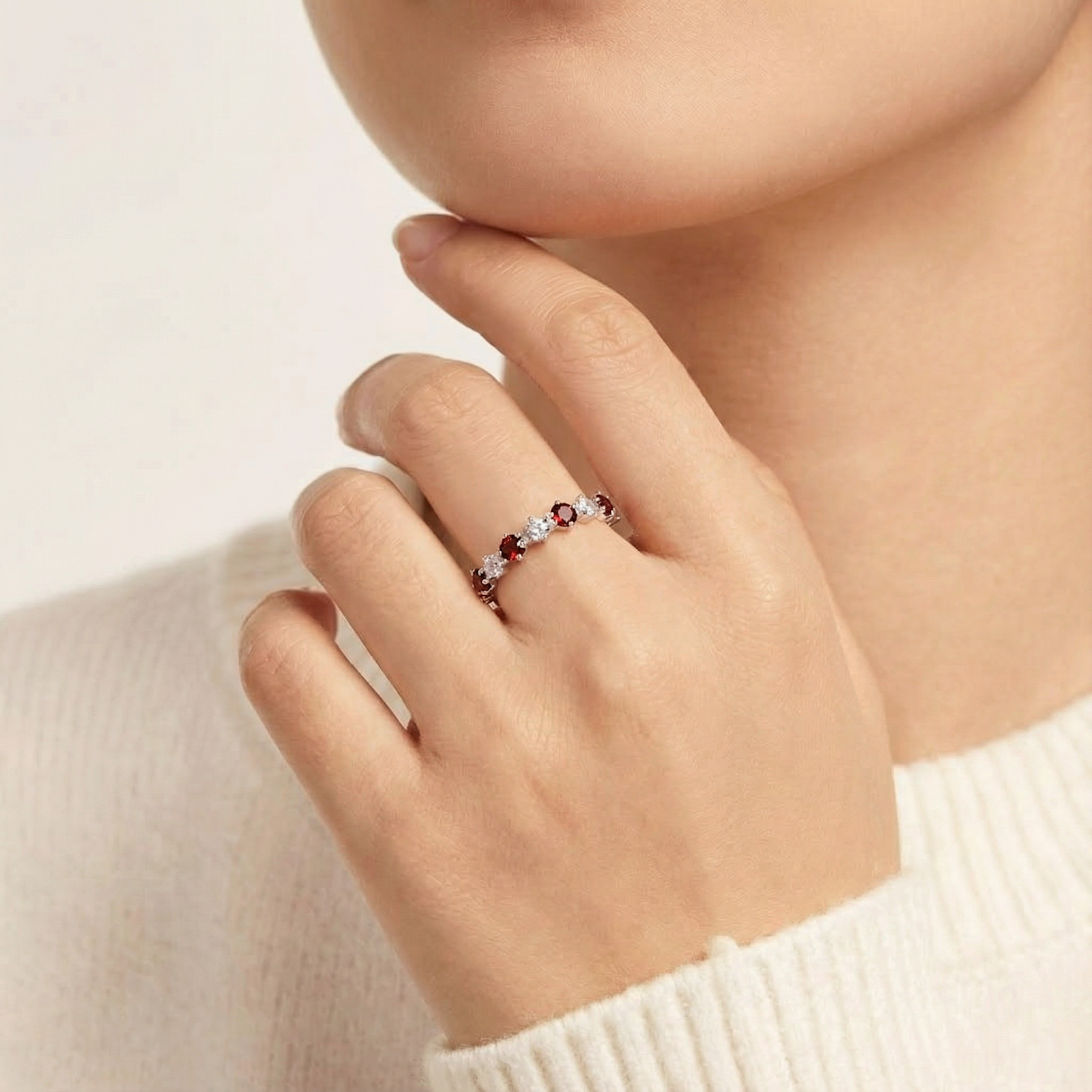 Model wearing the Aeliana S925 sterling silver eternity ring with round cut red and clear stones.